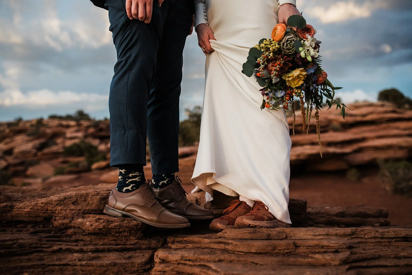 Bride and groom show off their footwear for a Moab elopement in Dead Horse Point