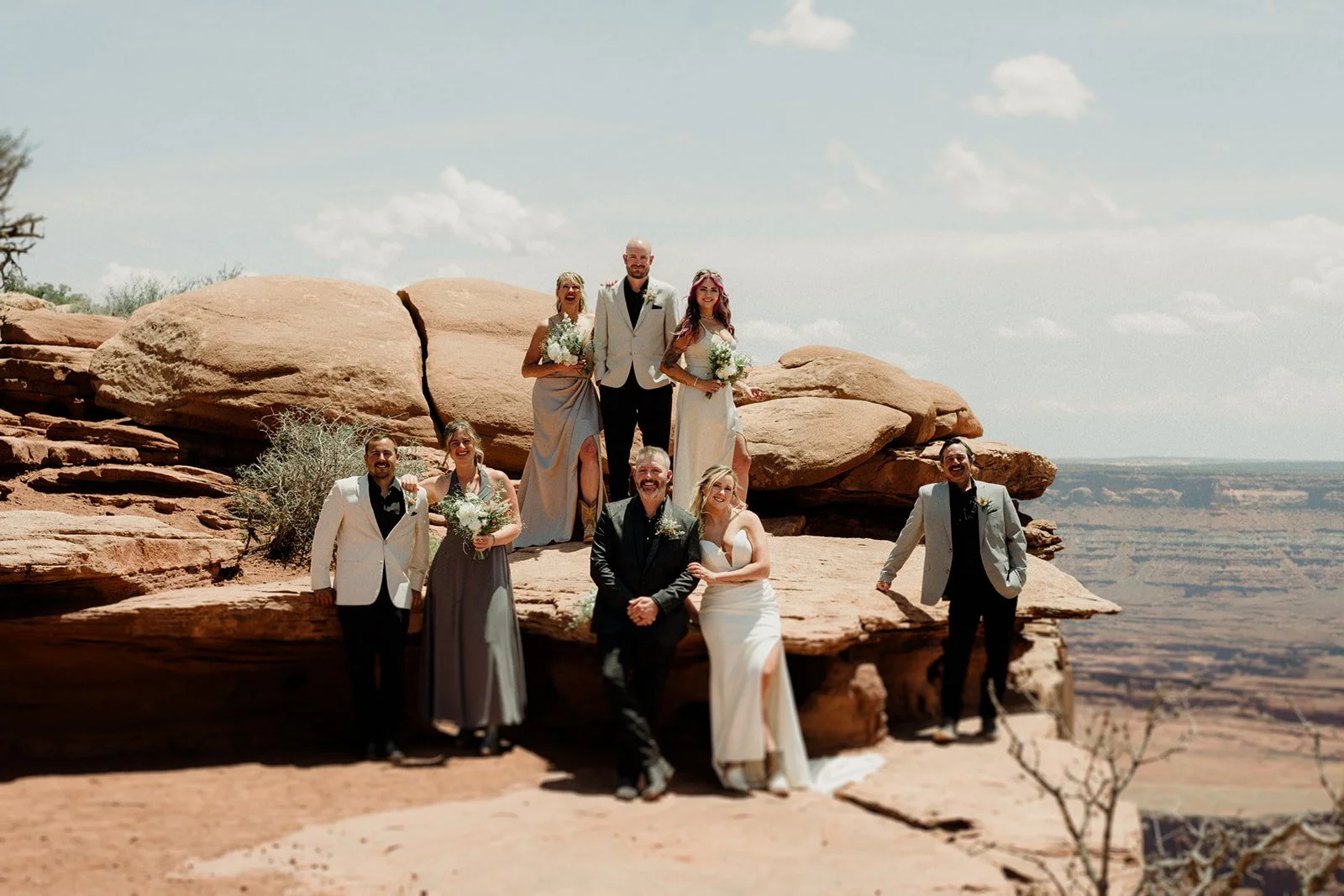 Wedding party poses for a photo at Dead Horse Point State Park looking over a vista after Moab Microwedding
