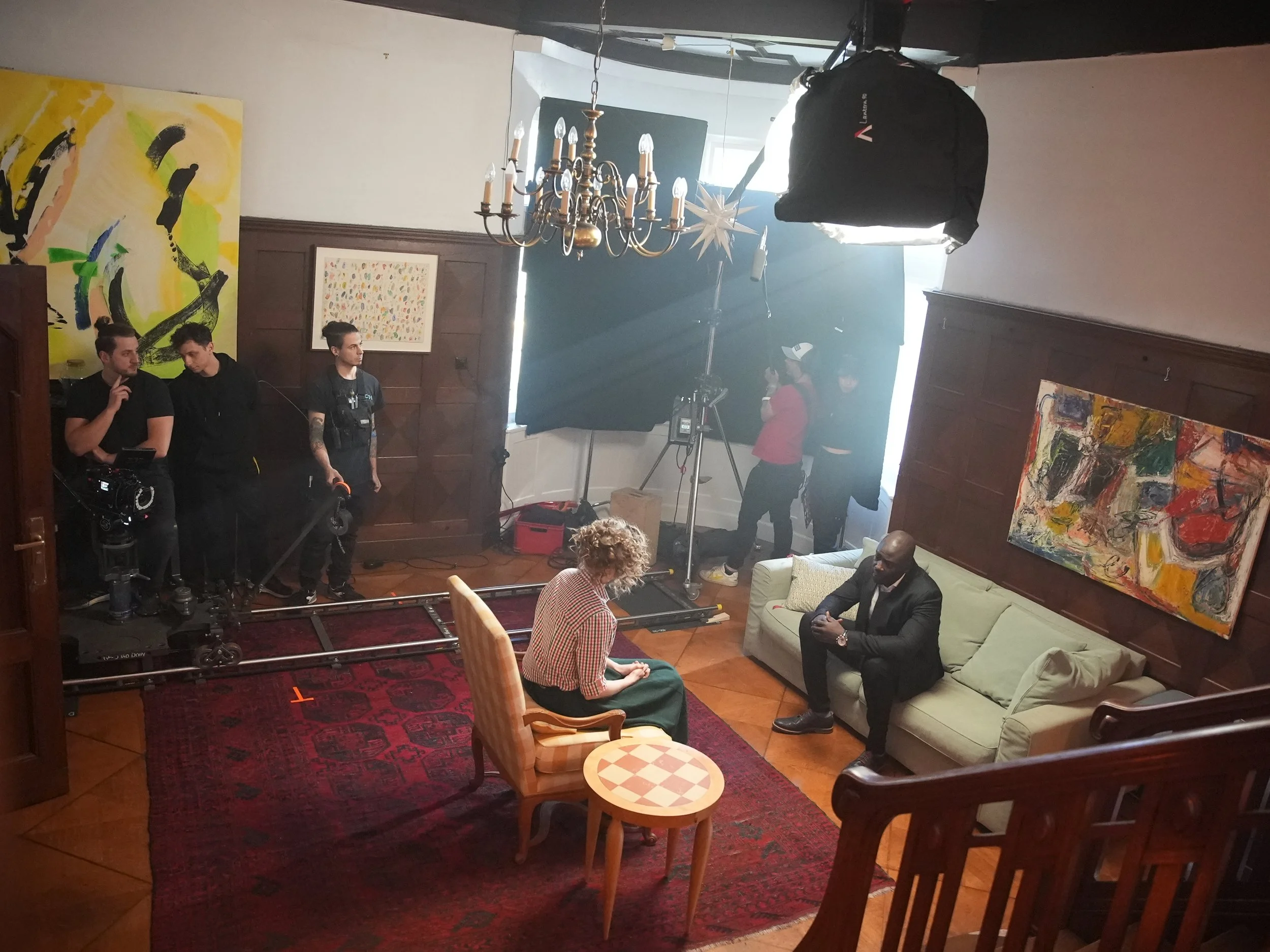 Troupe che illumina un set di soggiorno con binario per carrello e un grande softbox