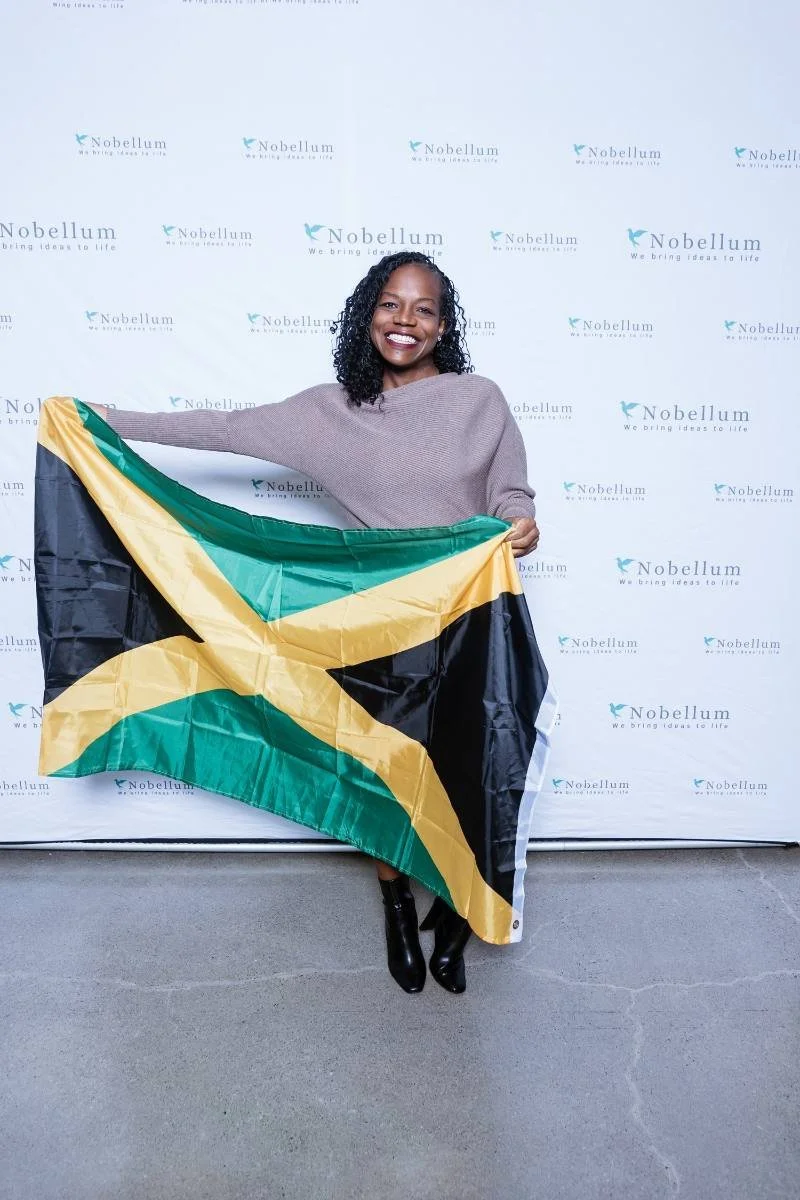 Nobellum founder holding a Jamaican flag at the CEI Global launch