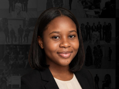 A young African American woman with shoulder-length straight hair, wearing a black blazer and white top, smiling at the camera.