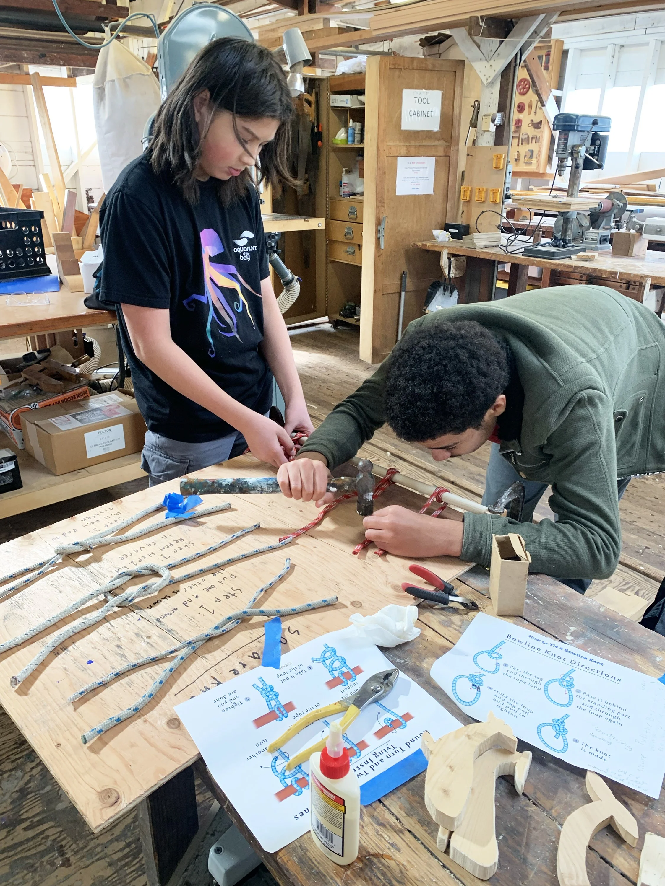 Two teens working on a knots project.