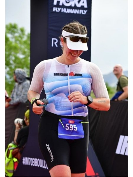Athlete crossing the finish line at Ironman 70.3 Boulder after completing a nine-month journey from beginner to Ironman 70.3 finisher.