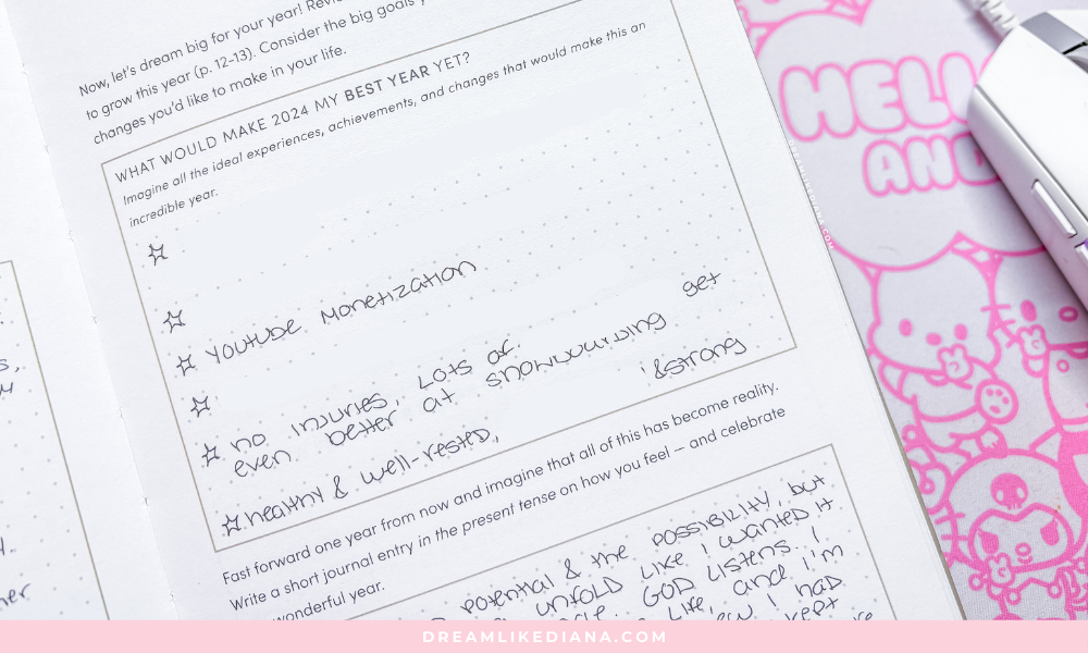 A handwritten journal page highlights 2024 goals like YouTube monetization and improved snowboarding. A whimsical pink mouse pad is partly visible.