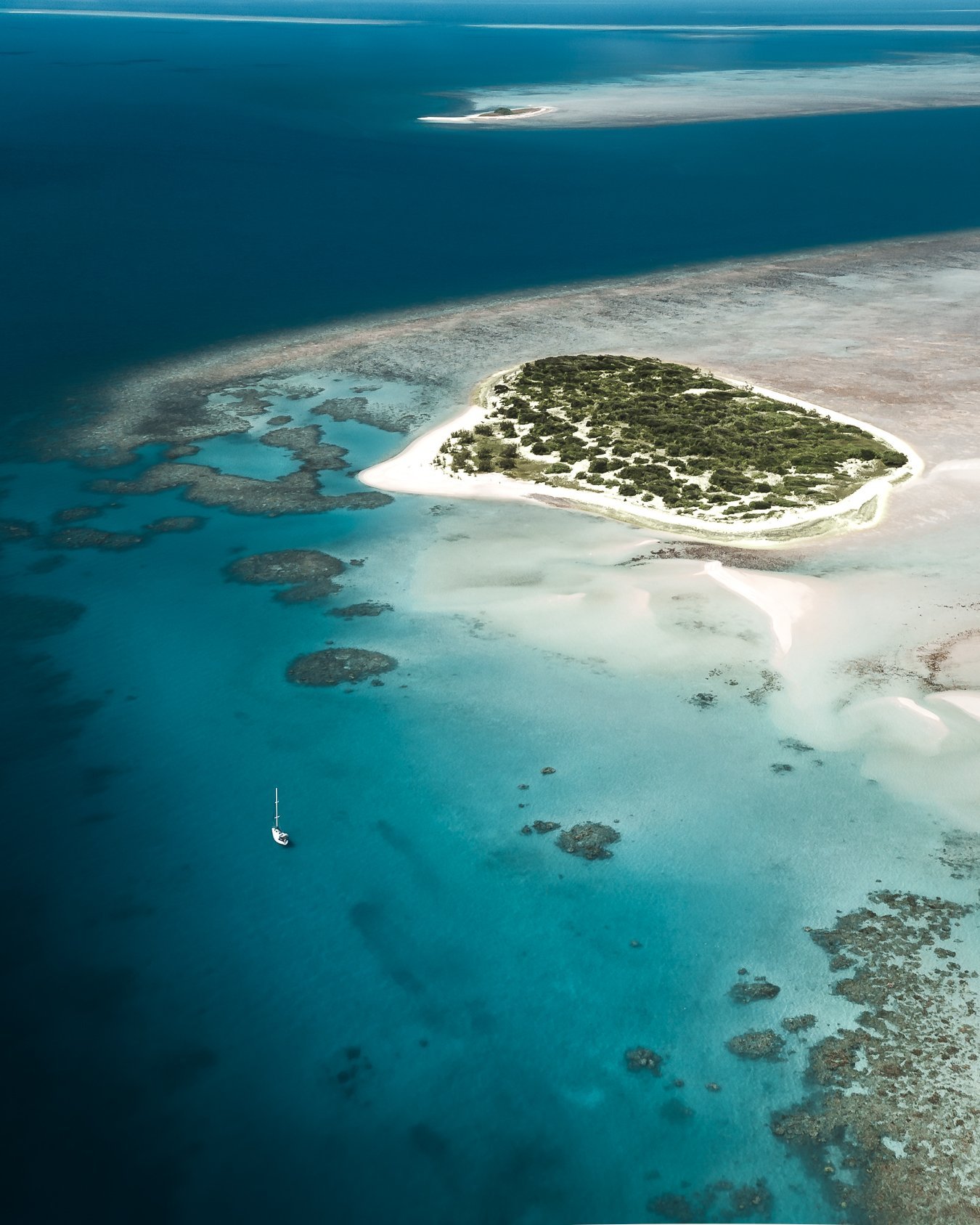 Bird’s eye view of beautiful Ingram island on the Great Barrier Reef and our sailing boat, Haven.