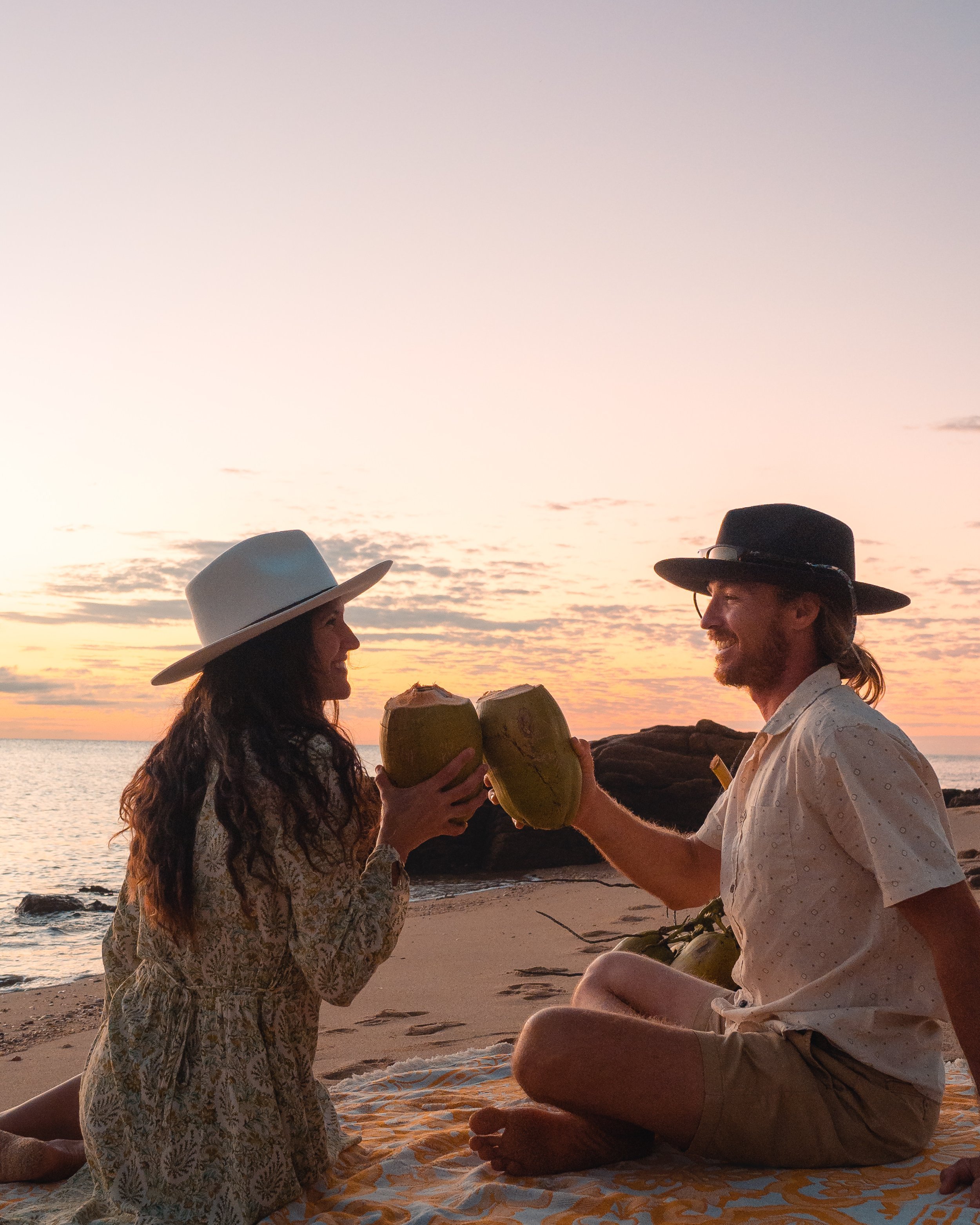 Our favourite way to watch the sun go down - on a beach with a coconut in hand! Location: Hideaway Bay, Whitsundays, Queensland.