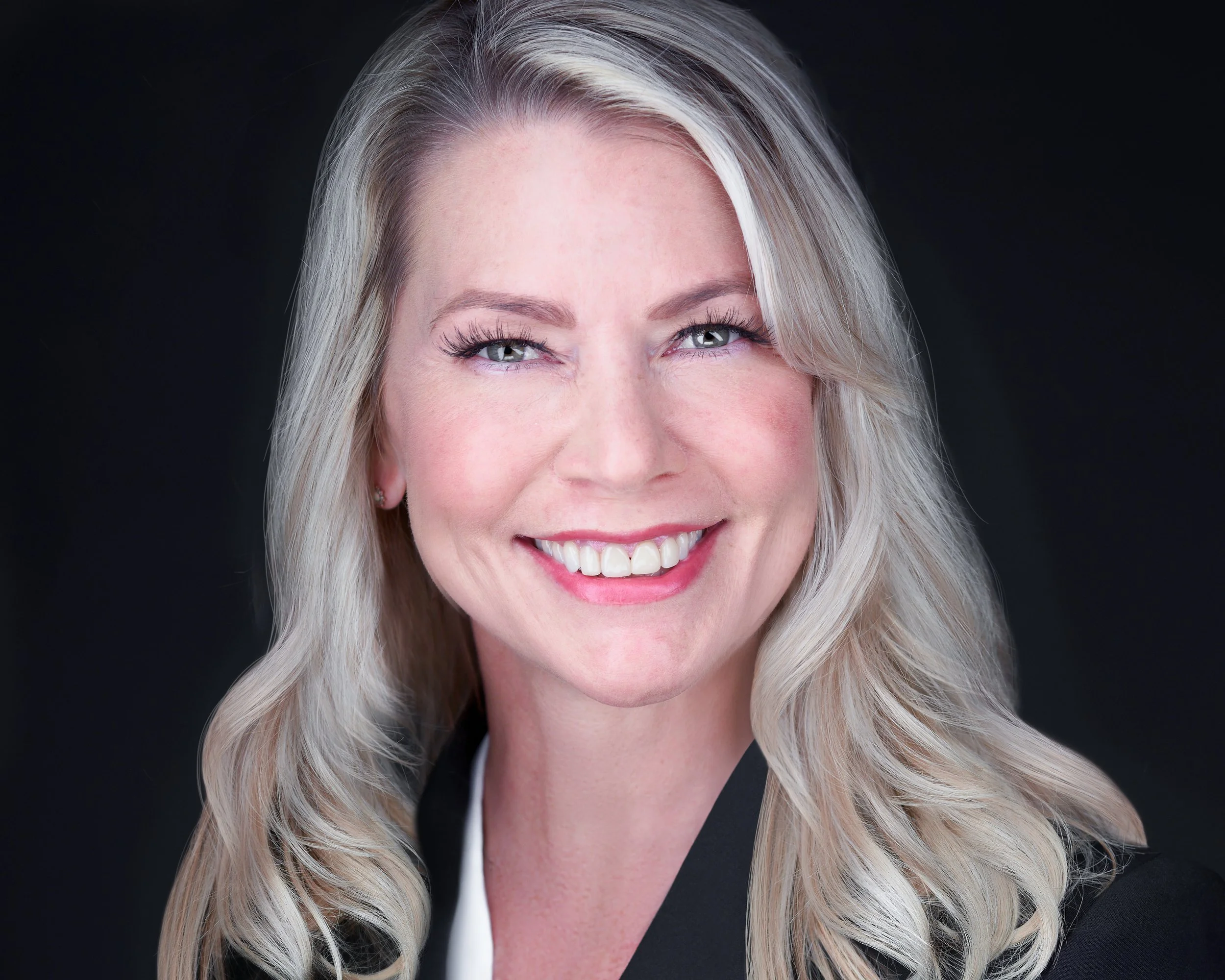 Professional Headshot with Natural Makeup and Soft Waves Against Dark Background.jpg