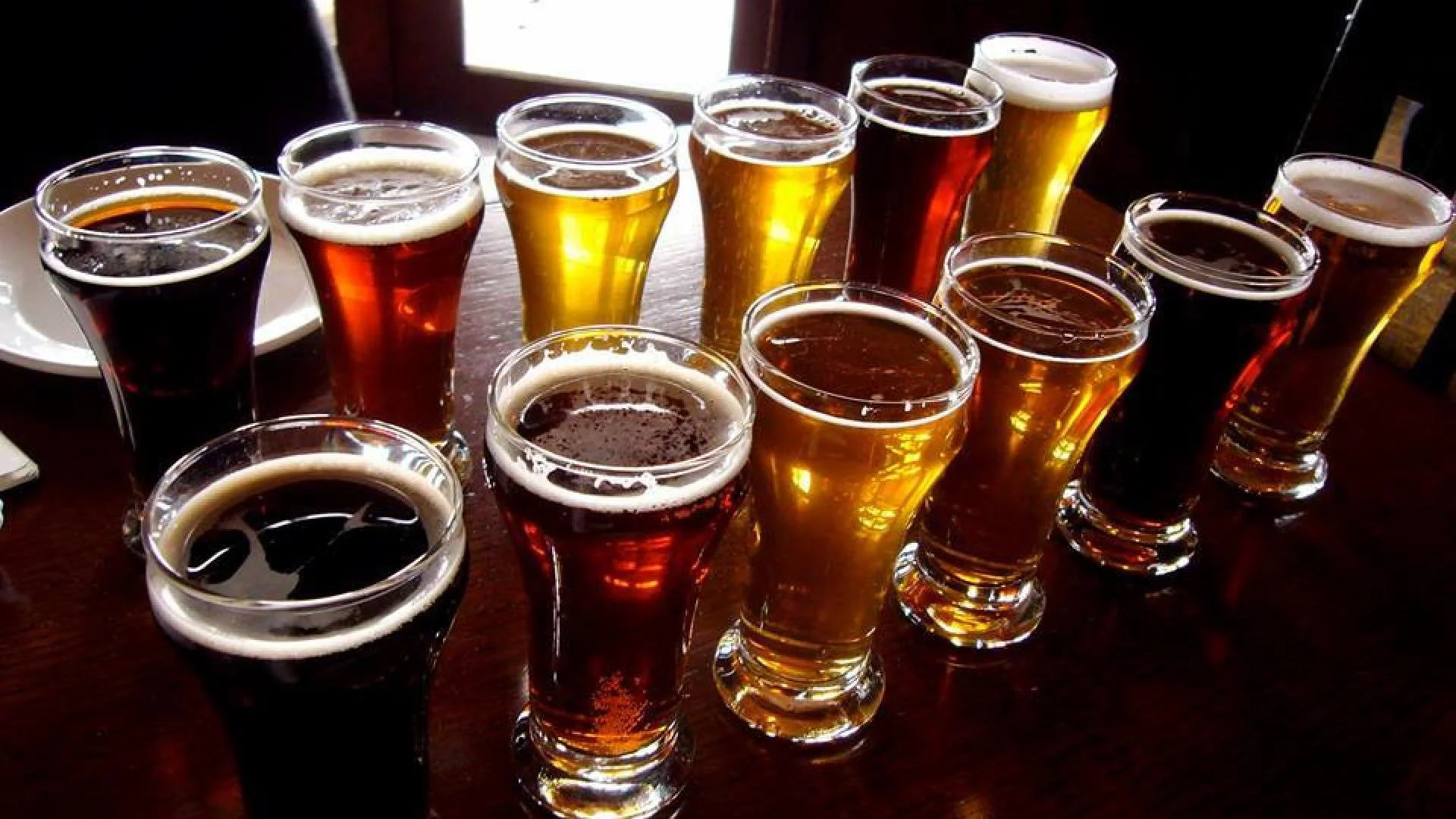several glasses of beer next to each other on a bar counter