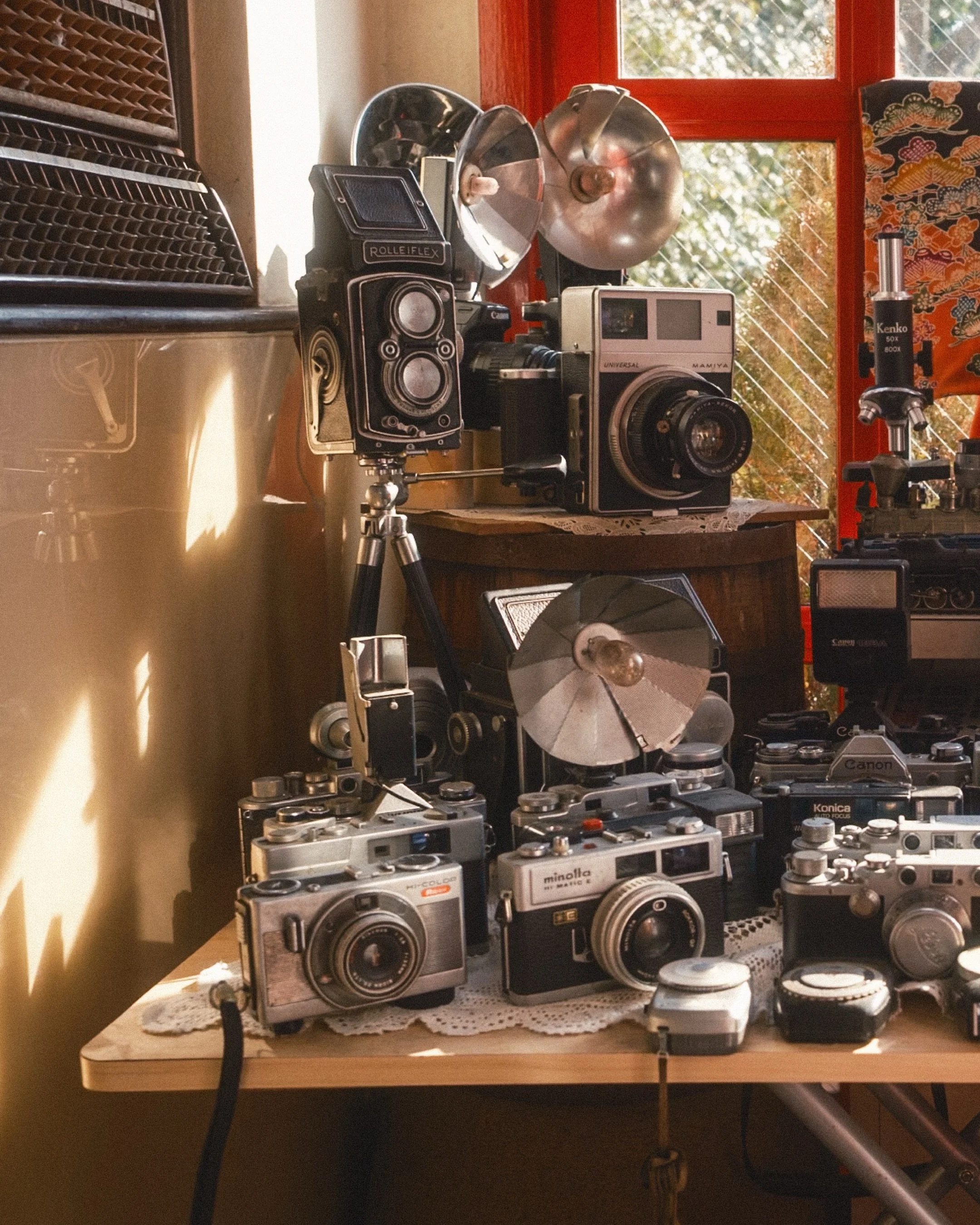 As soon as we walked in, we were presented with a shrine. But this was not the typical statue-and-burning-incense shrine. Warm, glowy light poured over a table filled with vintage cameras. All the major players are represented, from rangefinder Leica