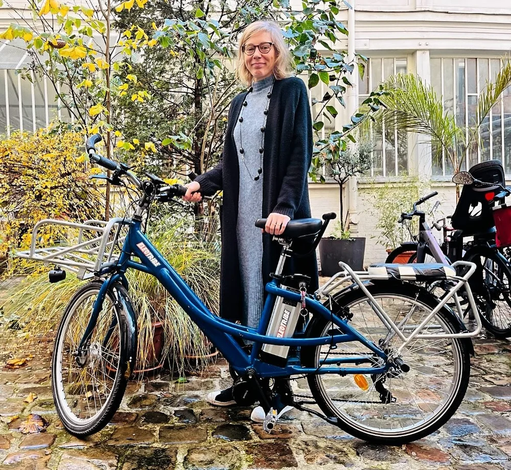 Nora et son ancien vélo La Poste électrifié par Electribe, à Paris