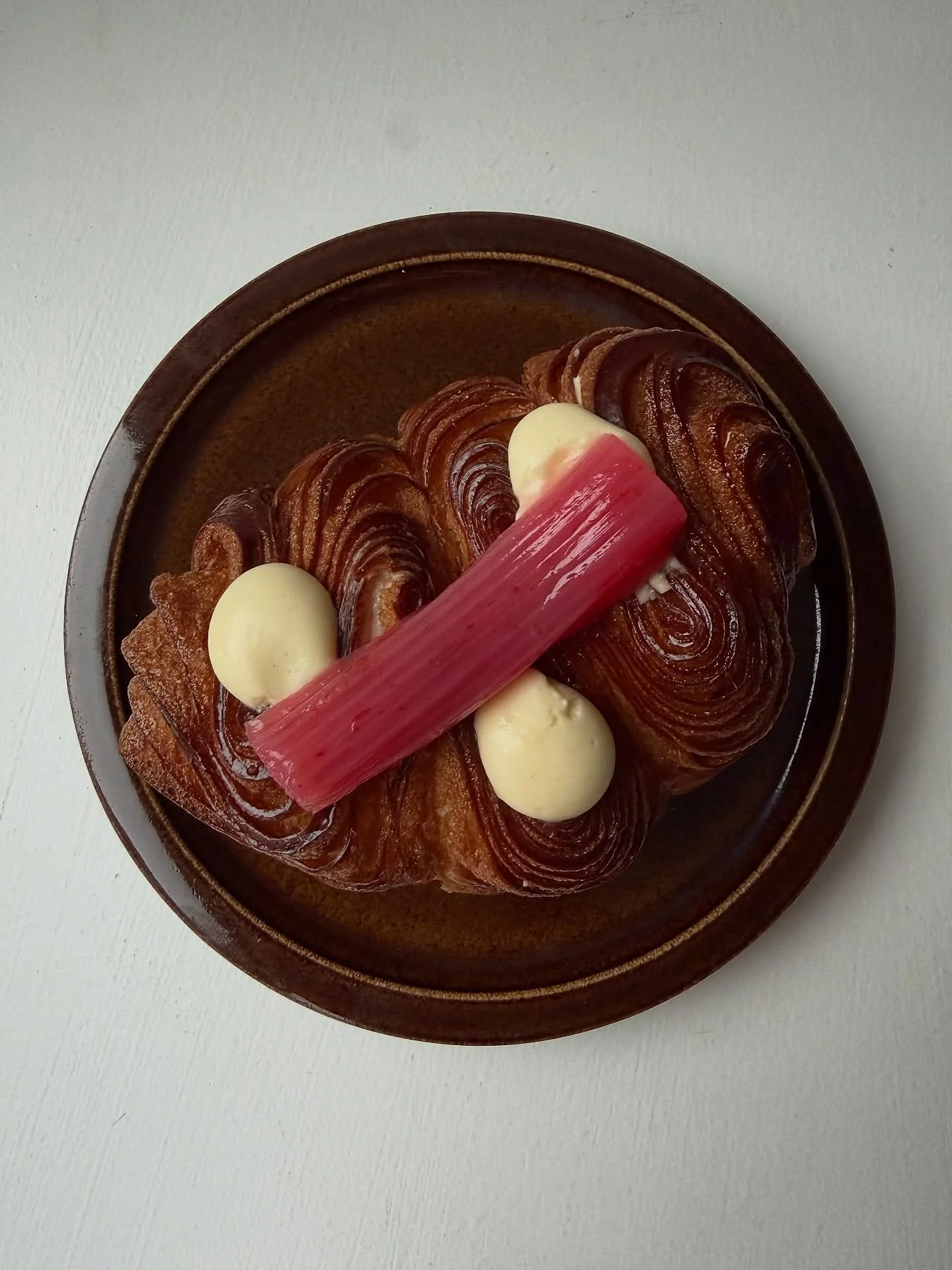 Rhubarb and Custard.

Laminated brioche filled with early rhubarb and ginger jam and whipped vanilla custard. Topped with poached early rhubarb. 

On the counter daily 💕
