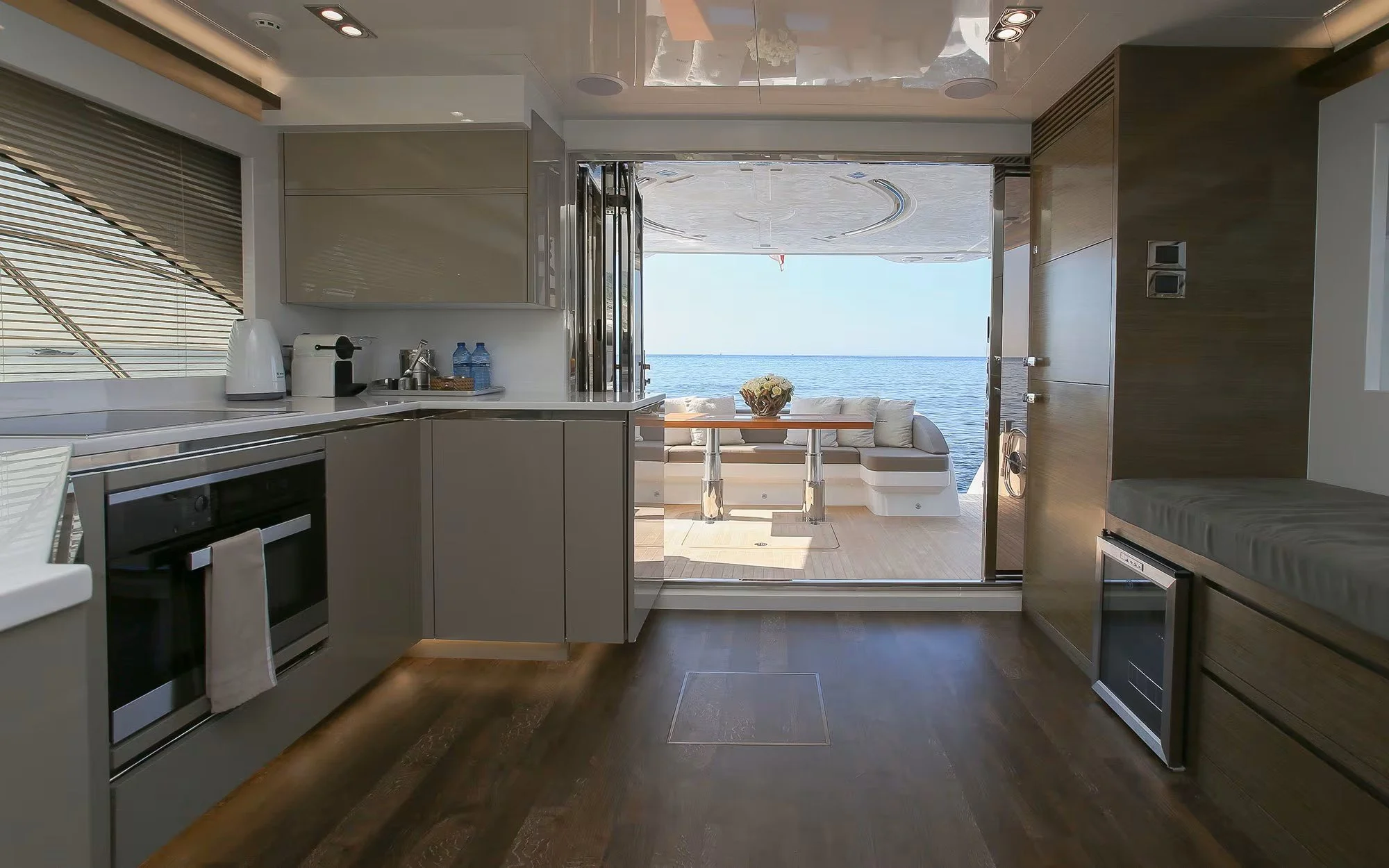 Modern kitchen with view of ocean outside, open patio with sofa and table.