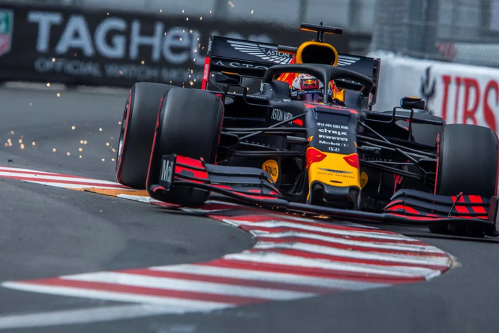 A Red Bull Racing Formula 1 car racing on a track with sparks flying from under the car as it navigates a turn.