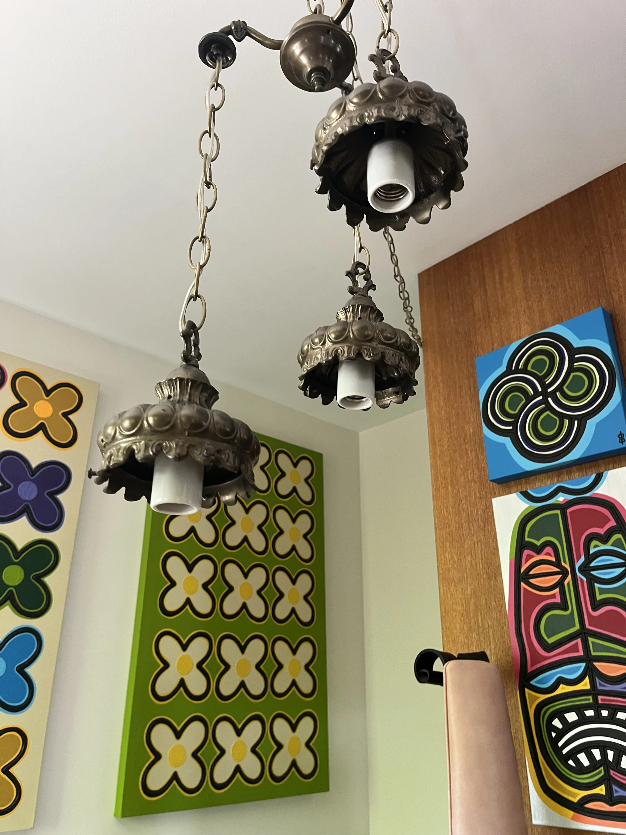Close-up of the sourced cast metal ceiling hardware and hanging chain of the vintage three-tier lamp.