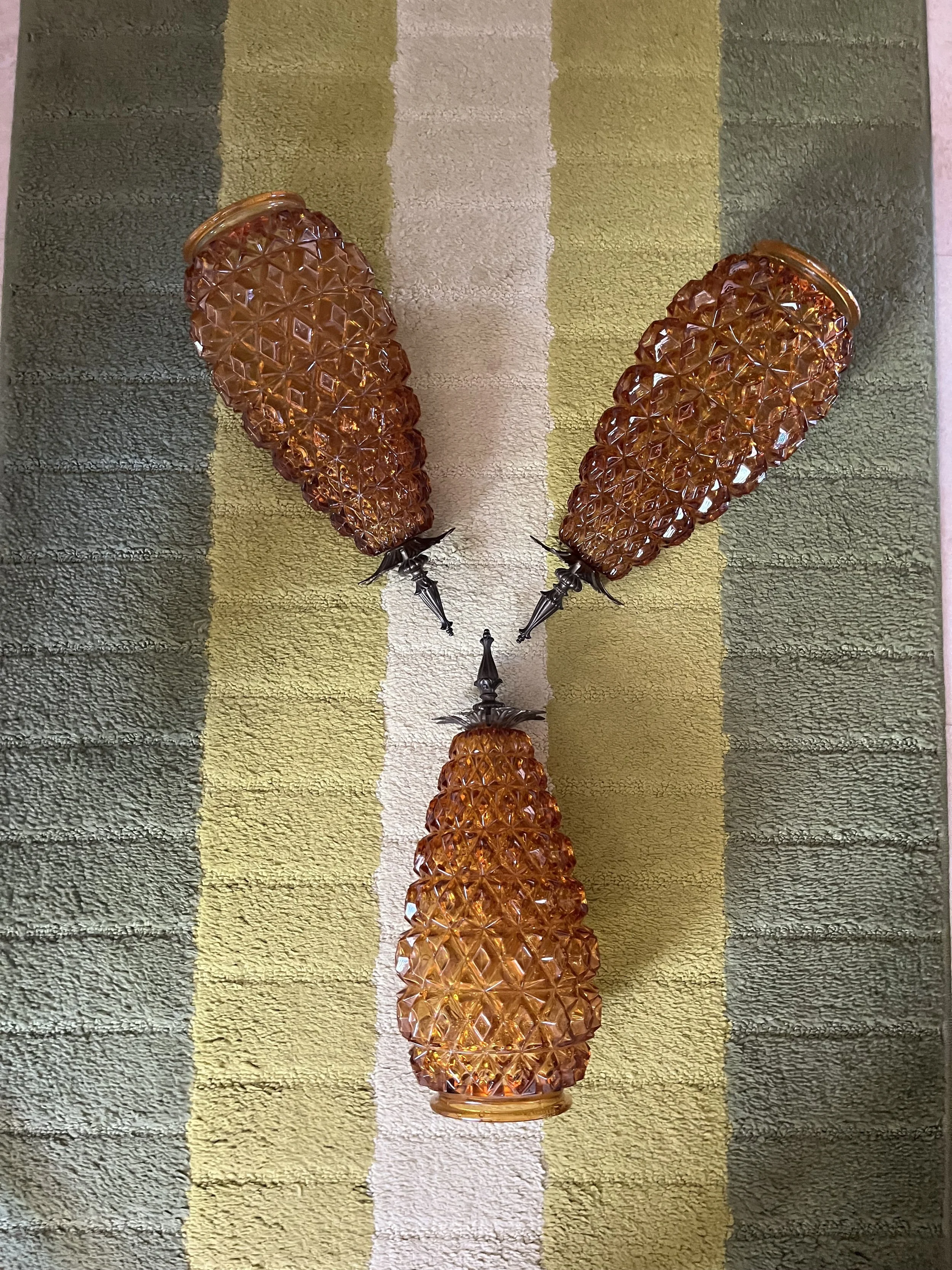 All three amber glass shades shown together beside a measuring tape to document their size and matching design.