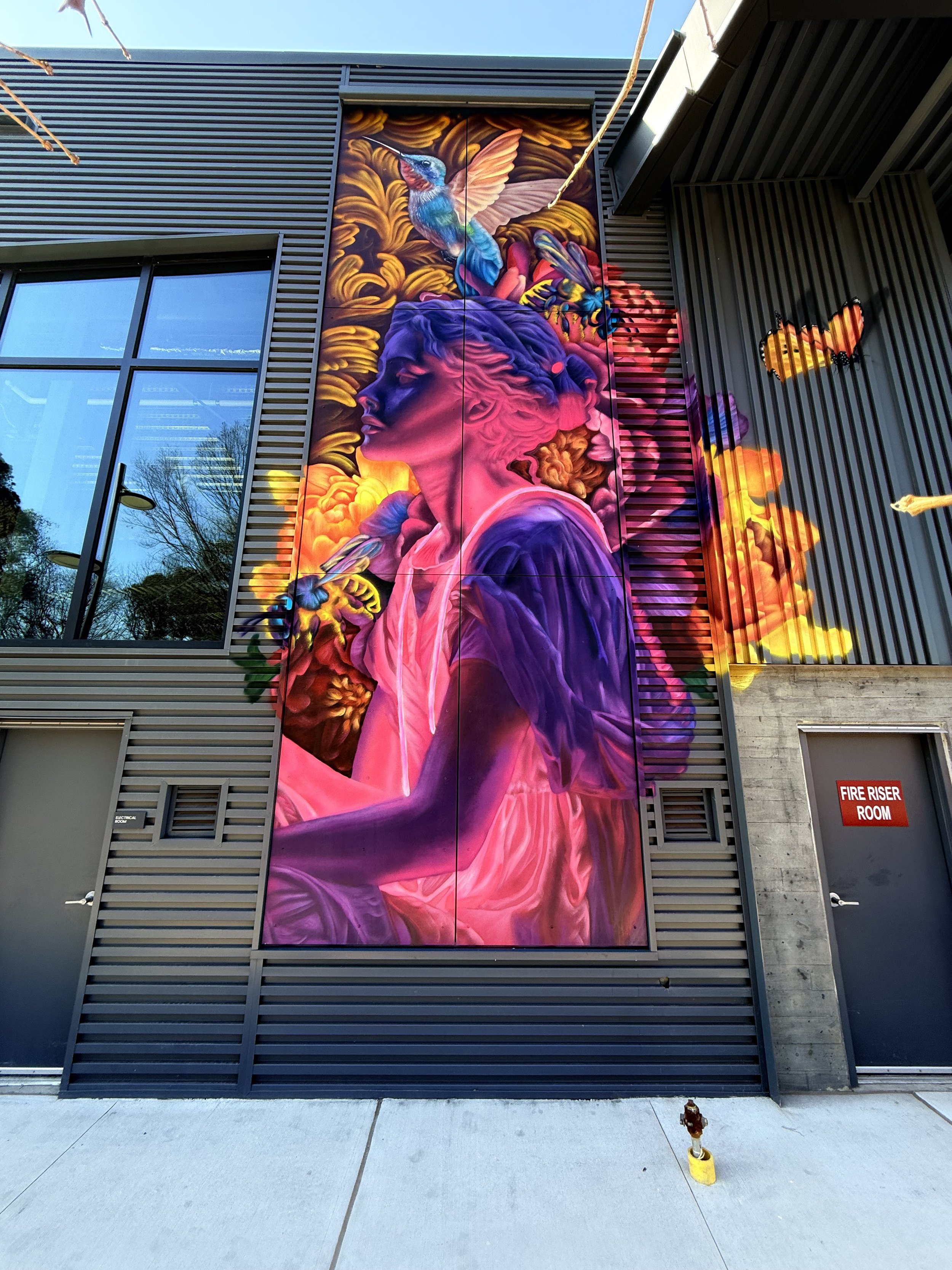 A colorful mural of a Greek statue woman painted by mural artist at a multi purpose development