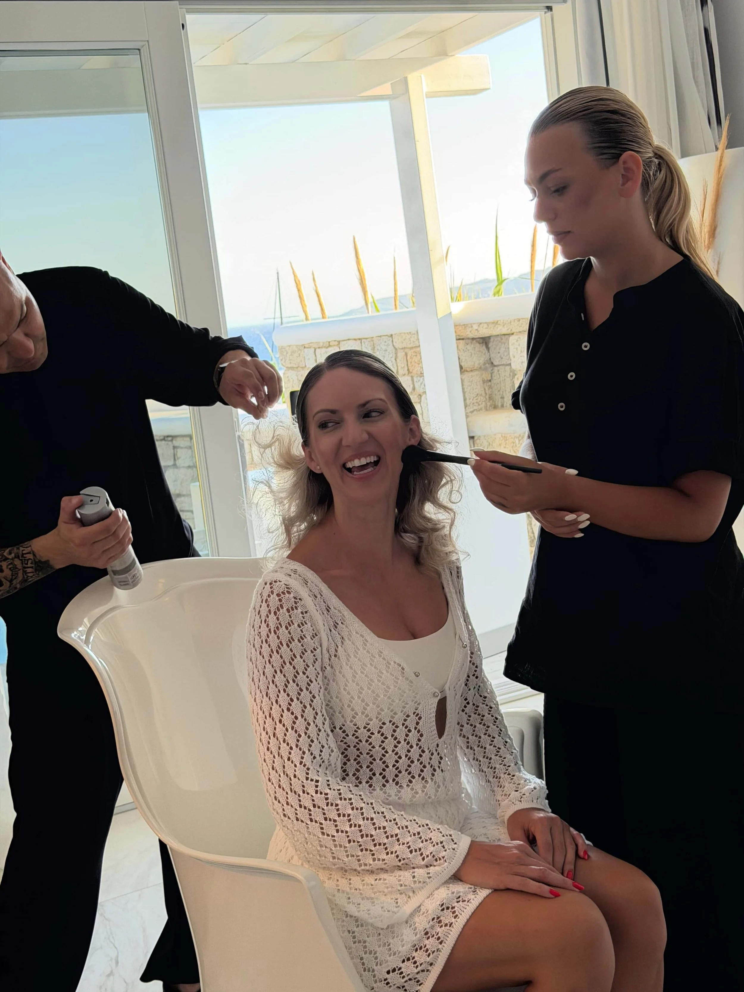 A happy bride in Athens riviera is having her bridal beauty services for makeup and hair by a team of artists - femme by [sēnsei]