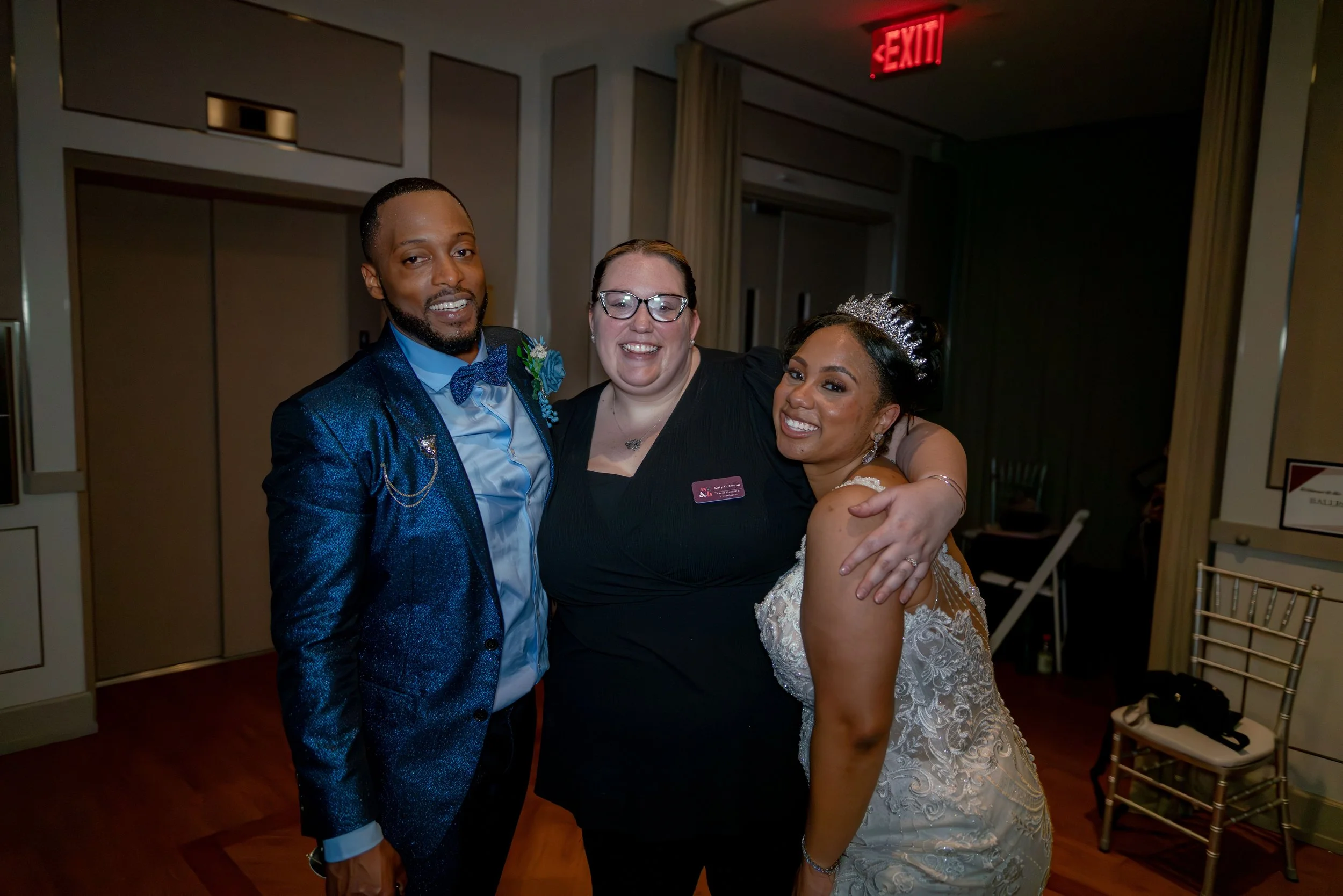 The wedding planner snaps a picture with the newlyweds.