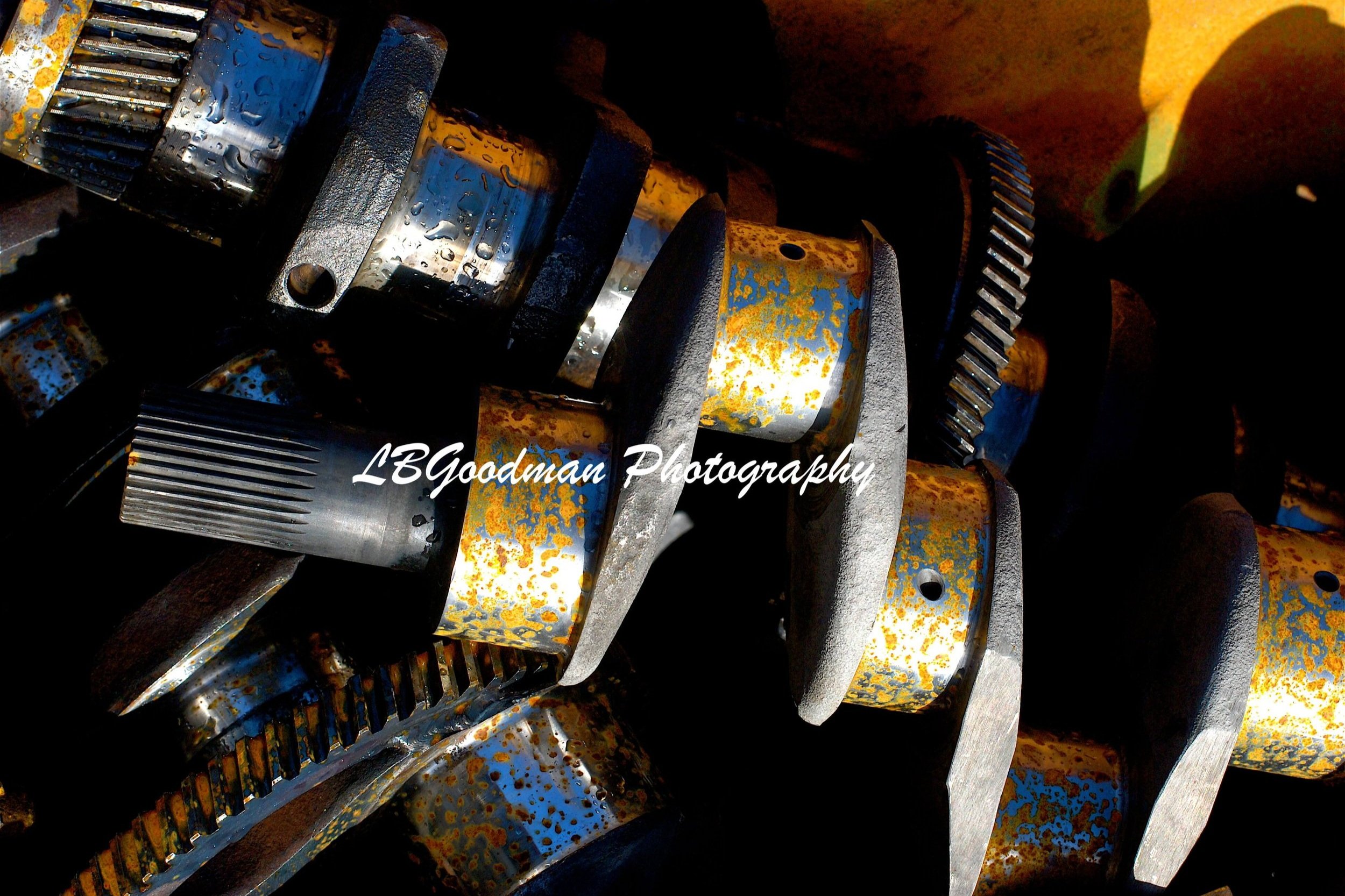 A professional photograph of metal tractor parts, featuring a white LBGoodman Photography watermark.