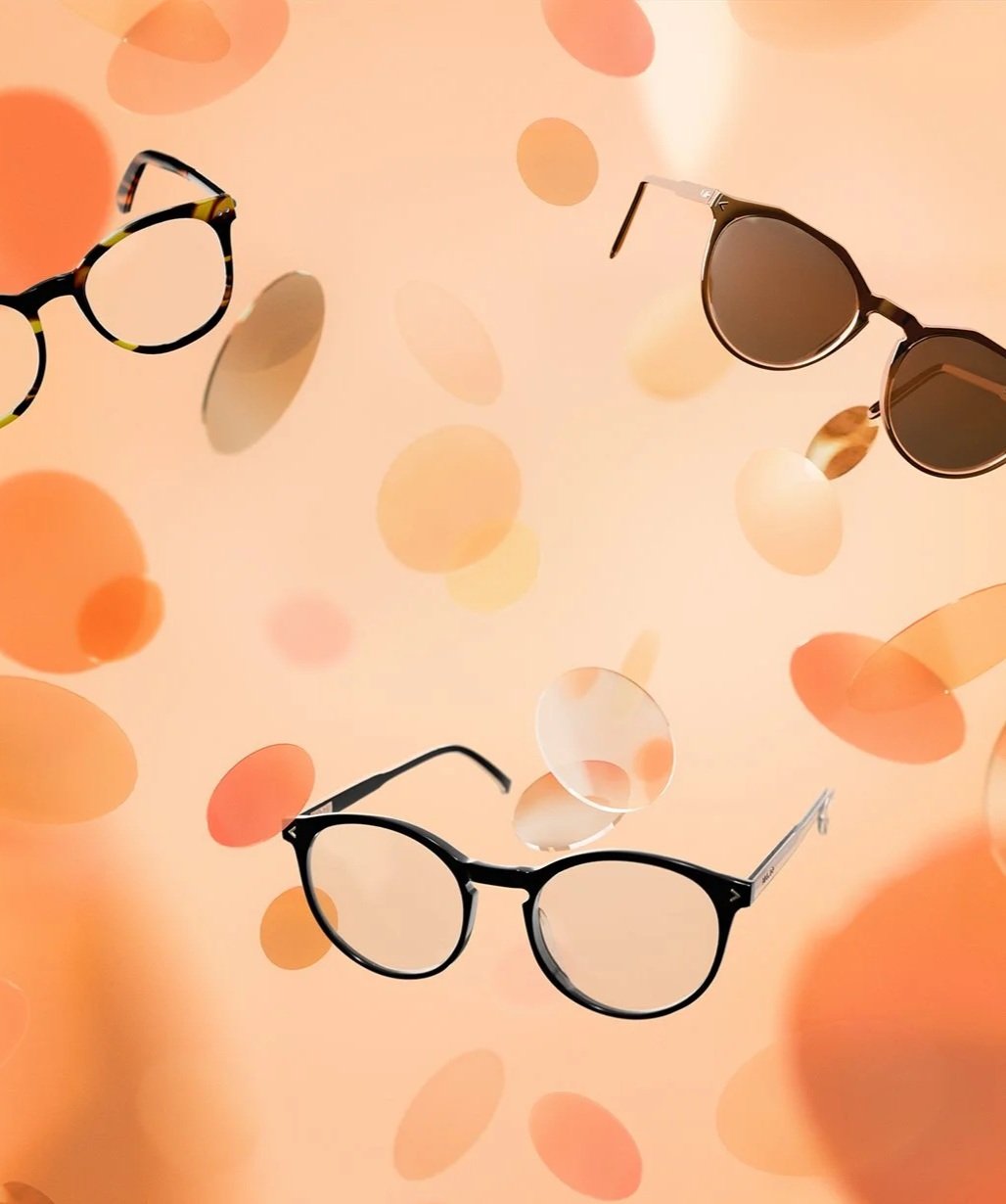 Tre par solglasögon flyger i luften mot en ljus, färgad bakgrund med cirkelformade mönster