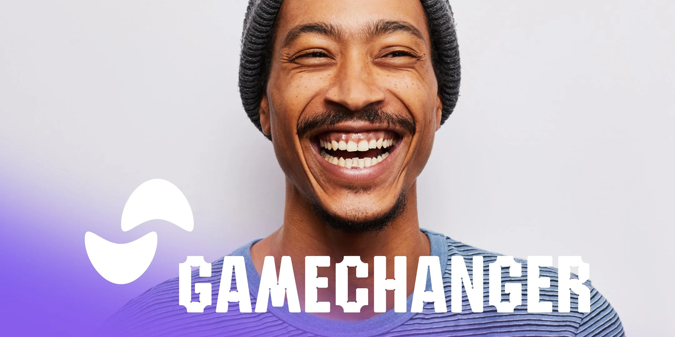 En leende man med mustasch och keps, texten 'GAMEMCHANGER' framför, vit bakgrund och en wave-symbol.