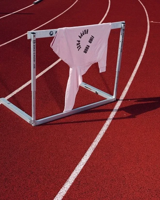 En vit tröja hängd på en träningshinder på en löparbana.