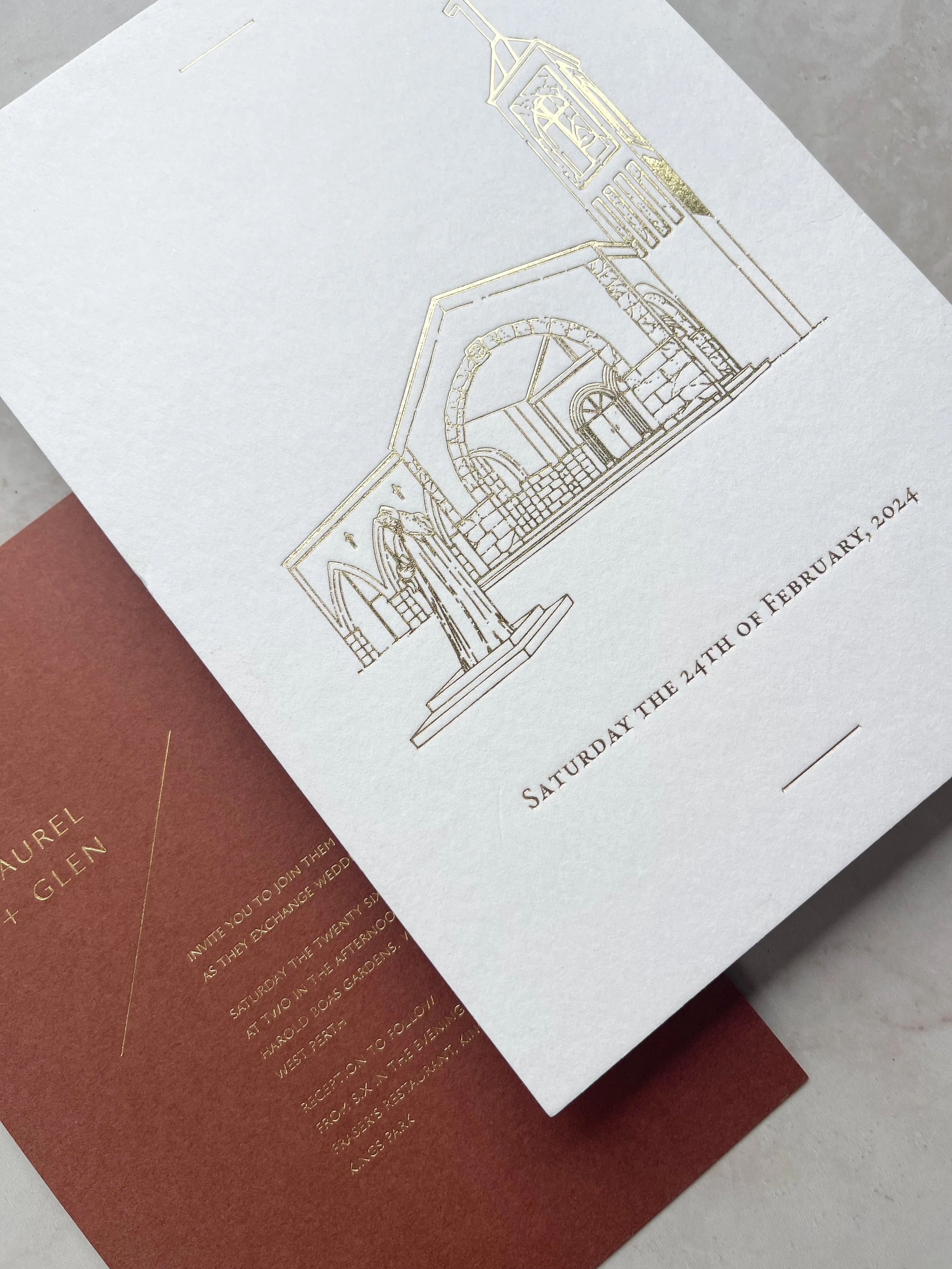 Close-up of invitation card with gold foil text