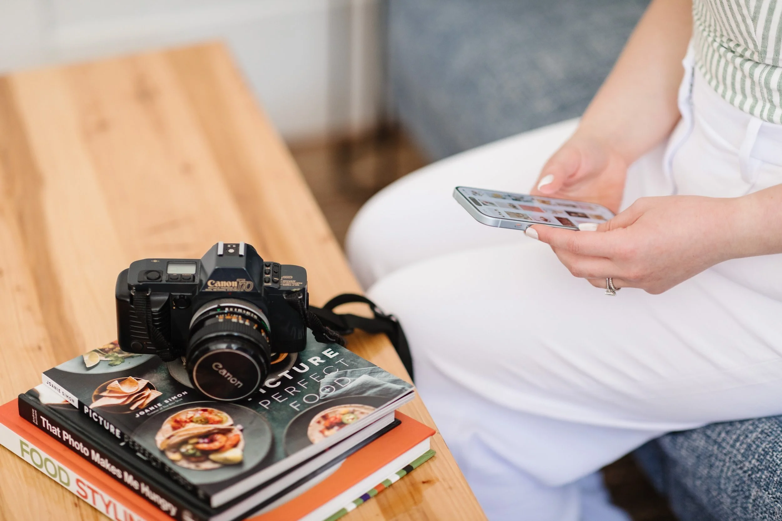 Woman looking at phone while sitting on a grey couch