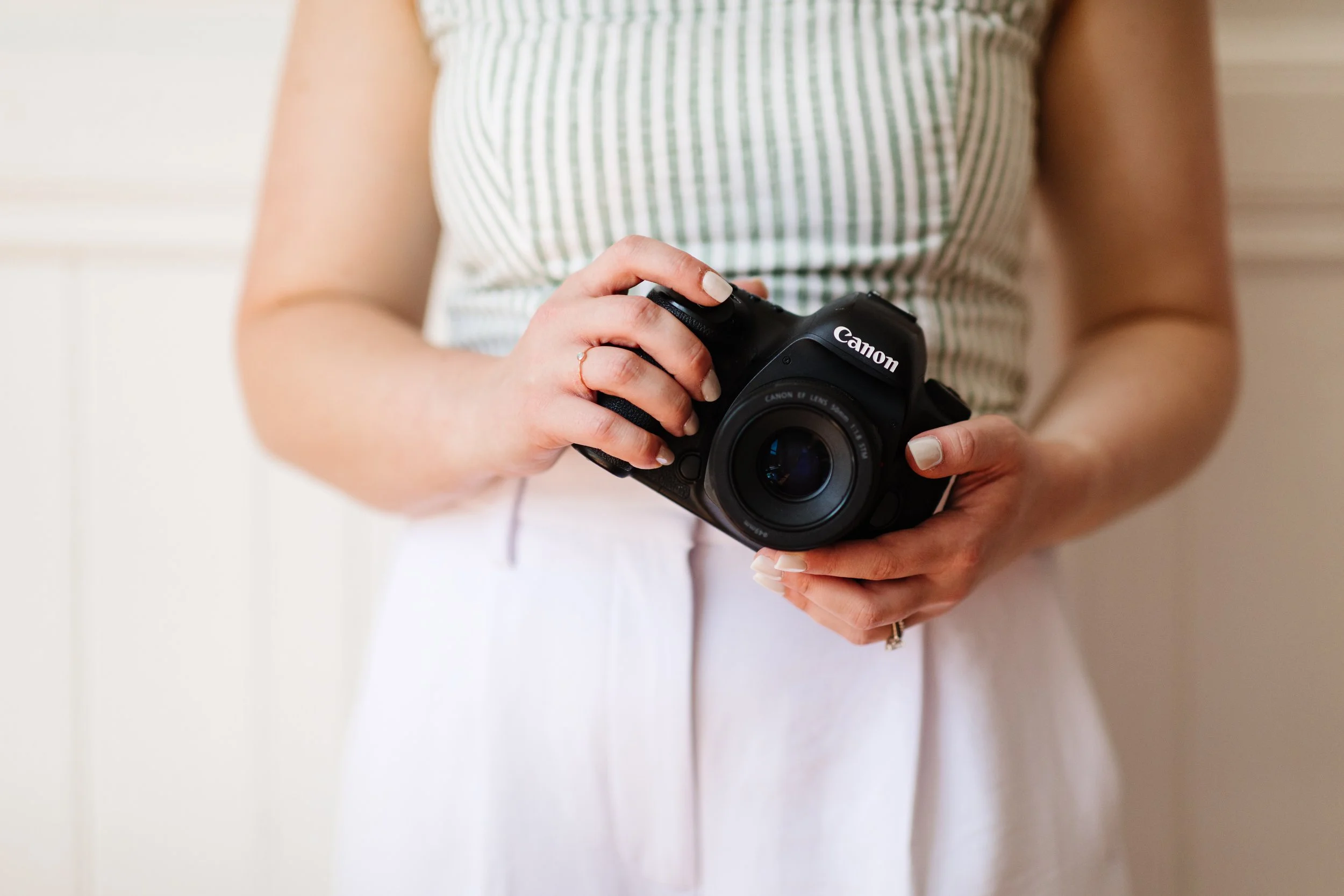 Hands holding a Canon 5D Mark IV Camera