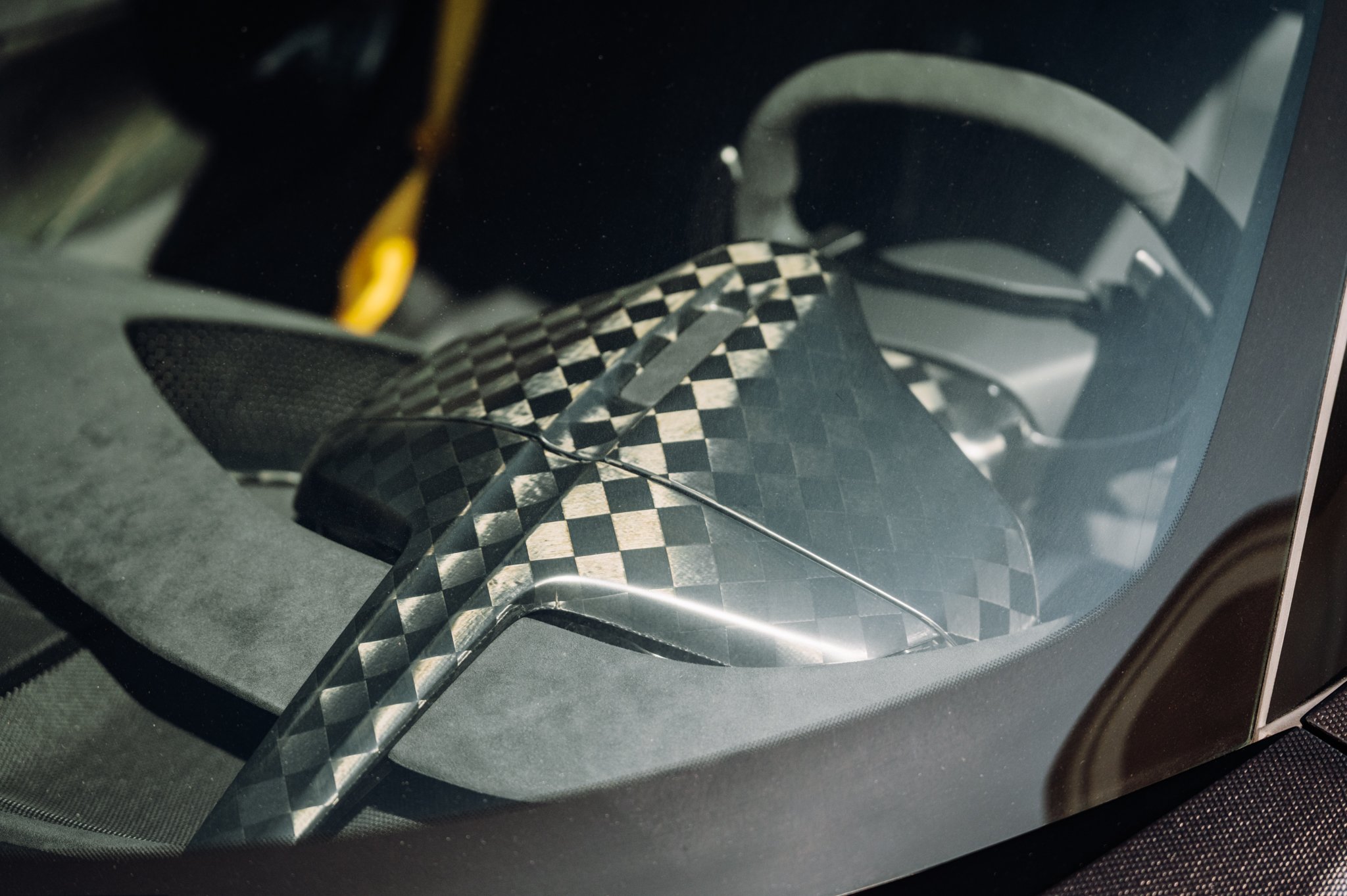 Close-up of a car dashboard with a carbon fiber pattern.