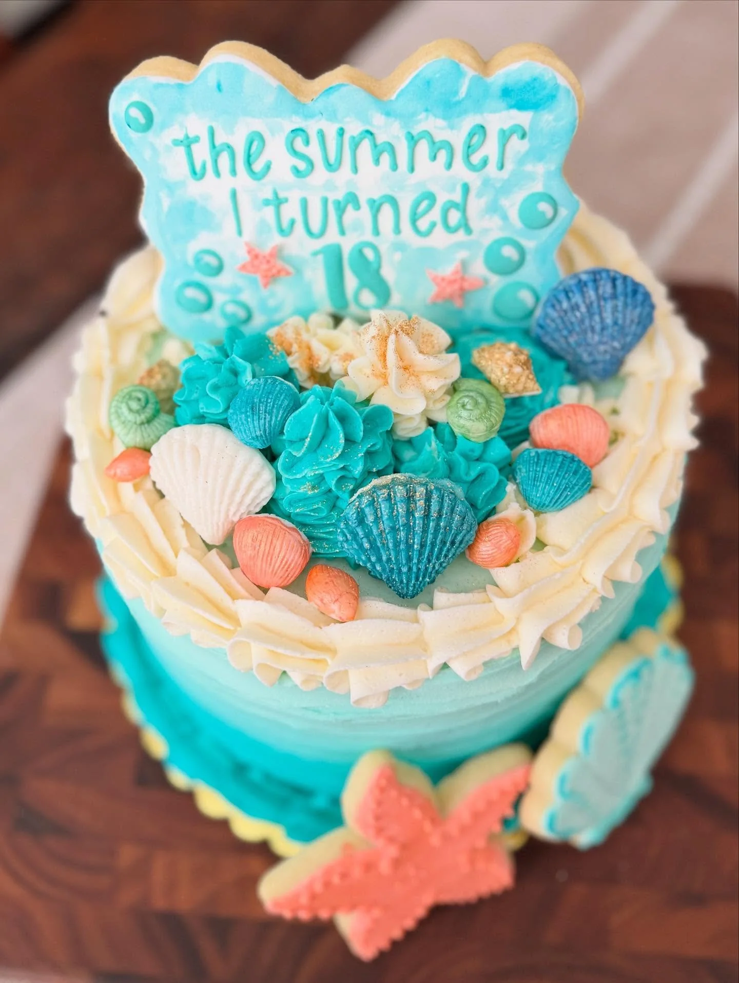 Happy 18th birthday to a very special girl! I hope you had the best day…welcome to adulthood!
This is a custom three-layer lemon cake with fluffy lemony buttercream, fondant shells, and of course, a cookie topper! 🤩
Do you have an upcoming