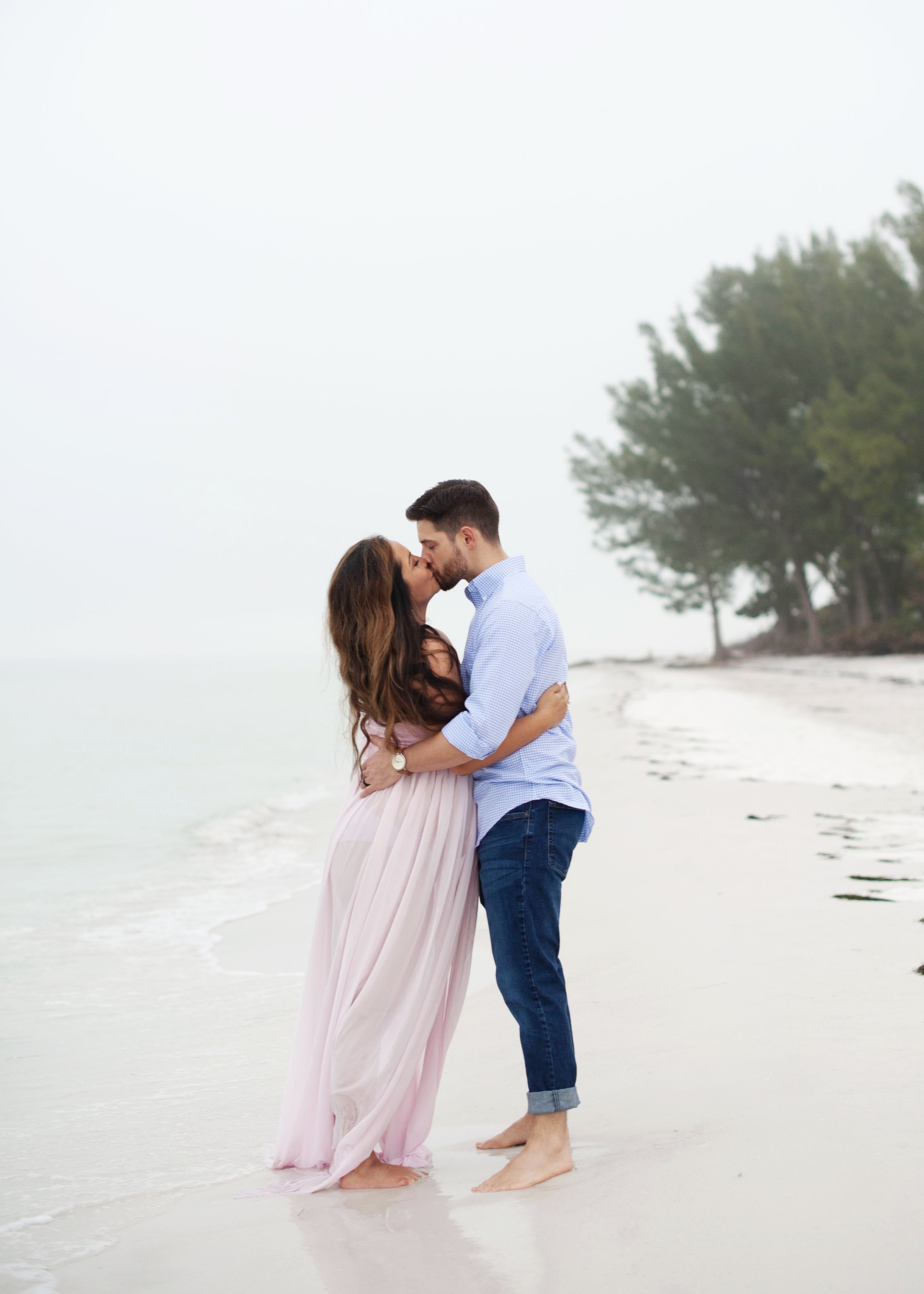 Maternity session on Anna Maria, with white sandy beaches and trees in the background.