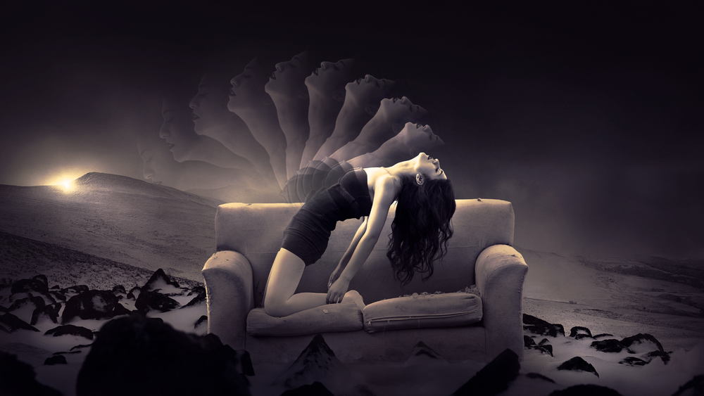 Woman on couch kneeling and astral projecting with her back arched in the middle of a desert at sunset.