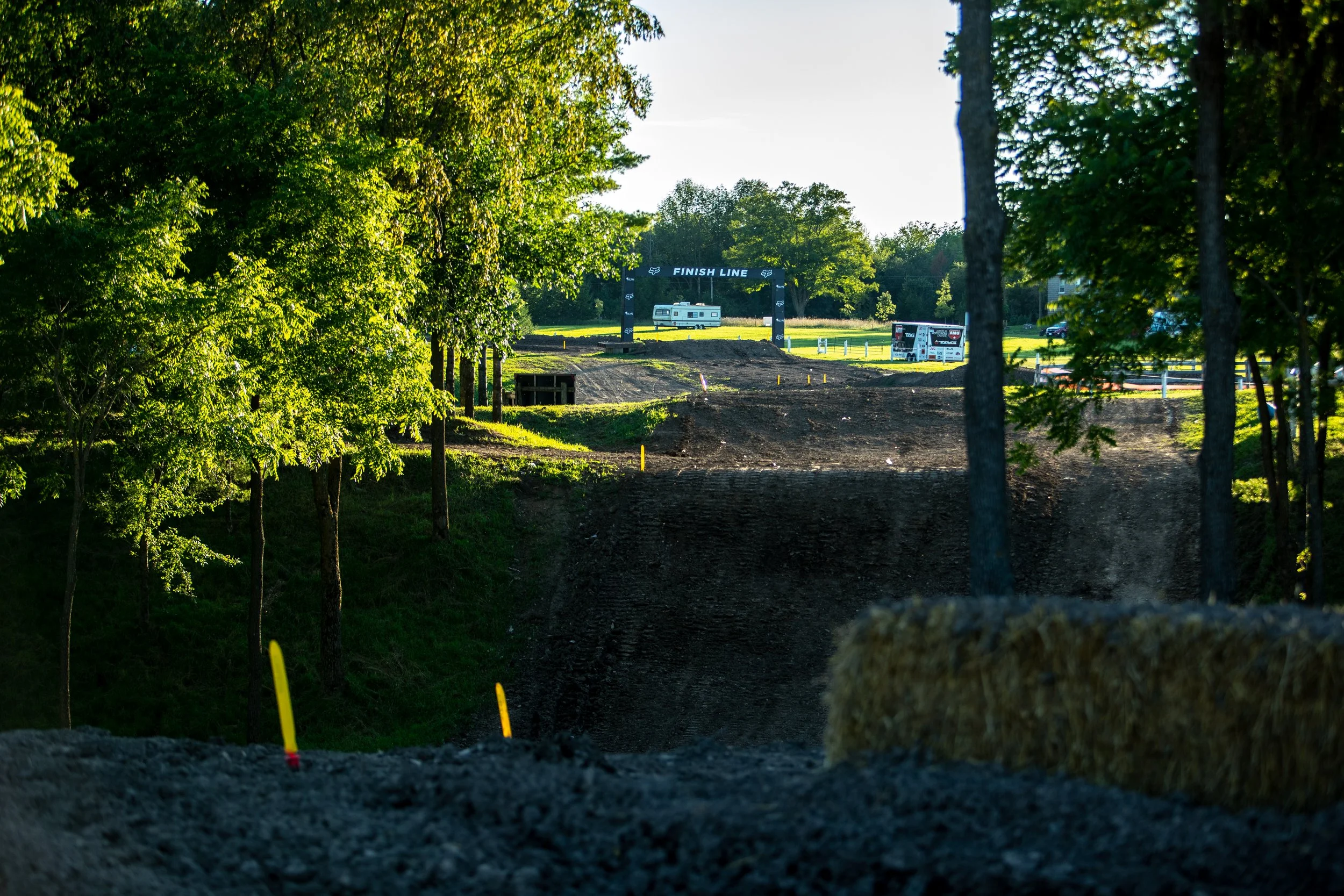 An image of the motocross track in Walton, looking through the trees at the Fox Finish Line arch.