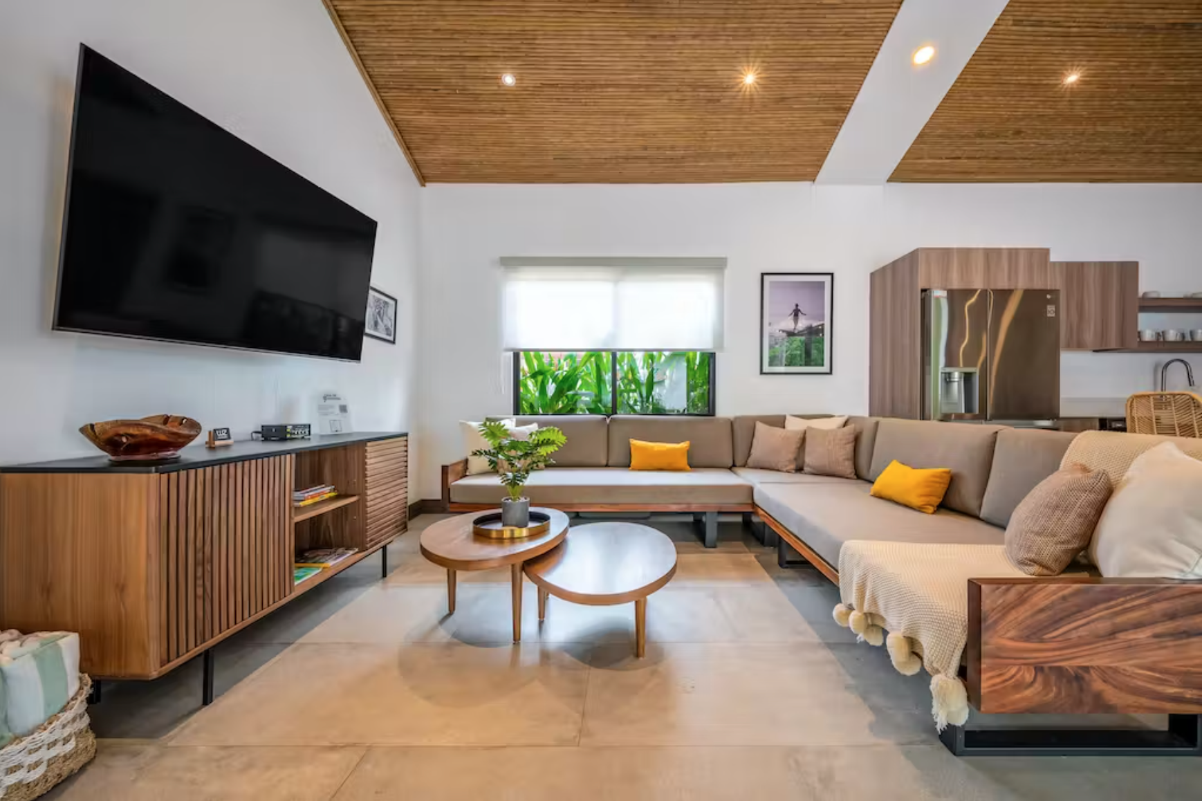 Unwind on the living room L-shape couch made by local woodworkers and enjoy the large smart TV and view of the pool.