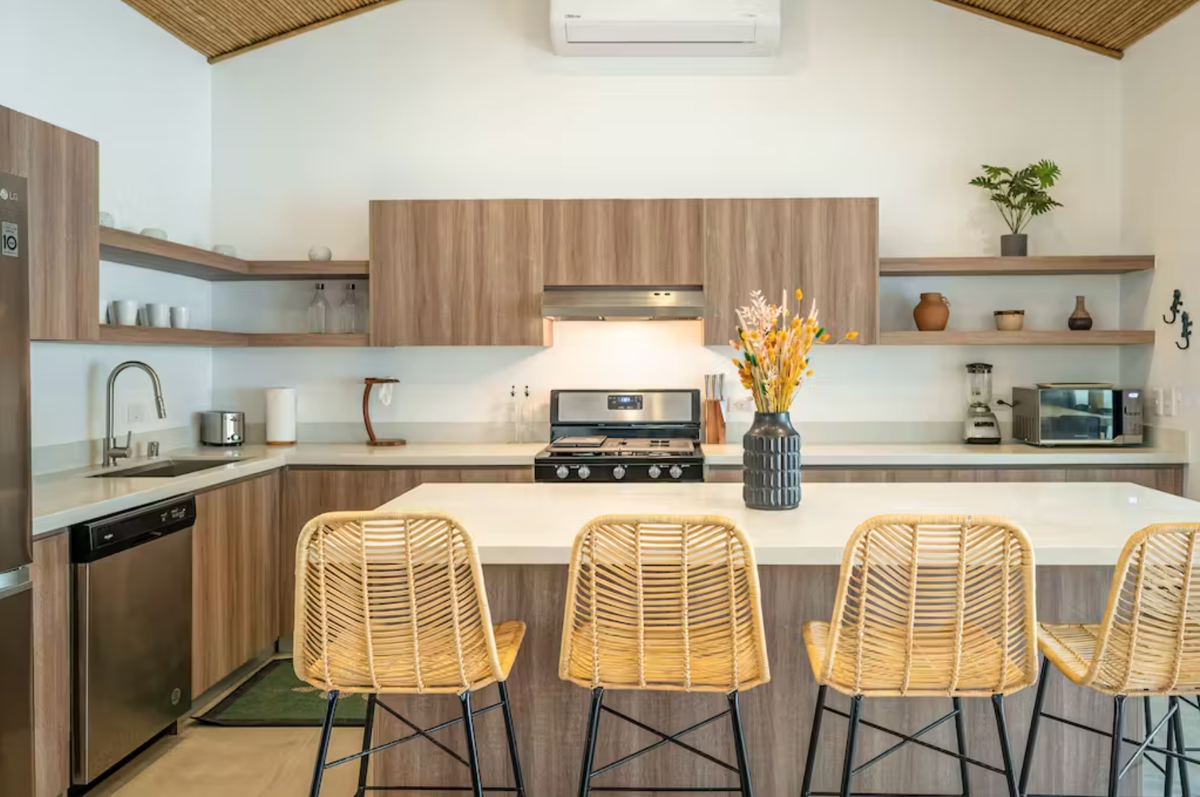 Kitchen with seating, full size fridge, freezer, dishwasher, and oven with gas range