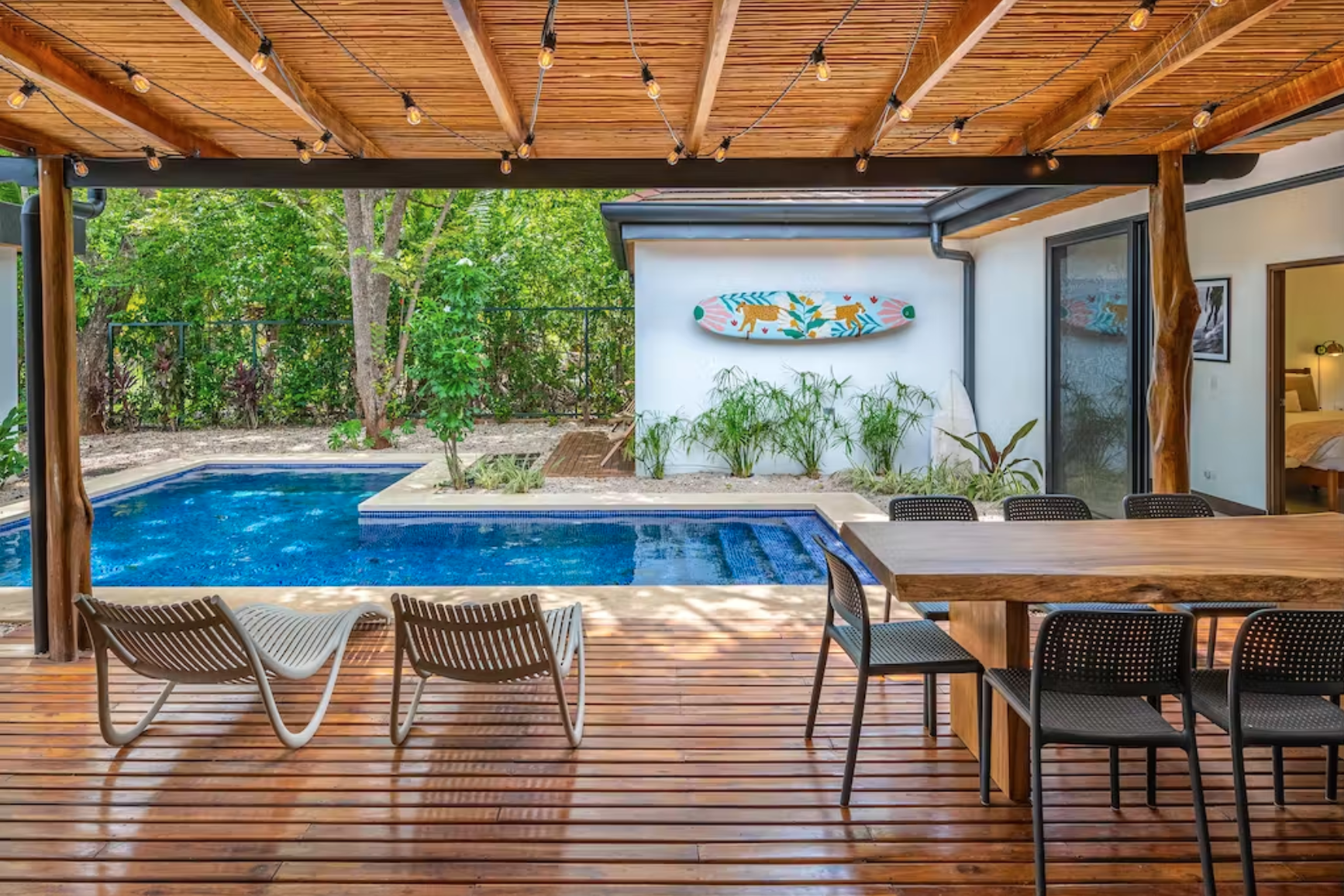 Your view of the private pool, covered patio, backyard, and original artwork from the kitchen and living area.
