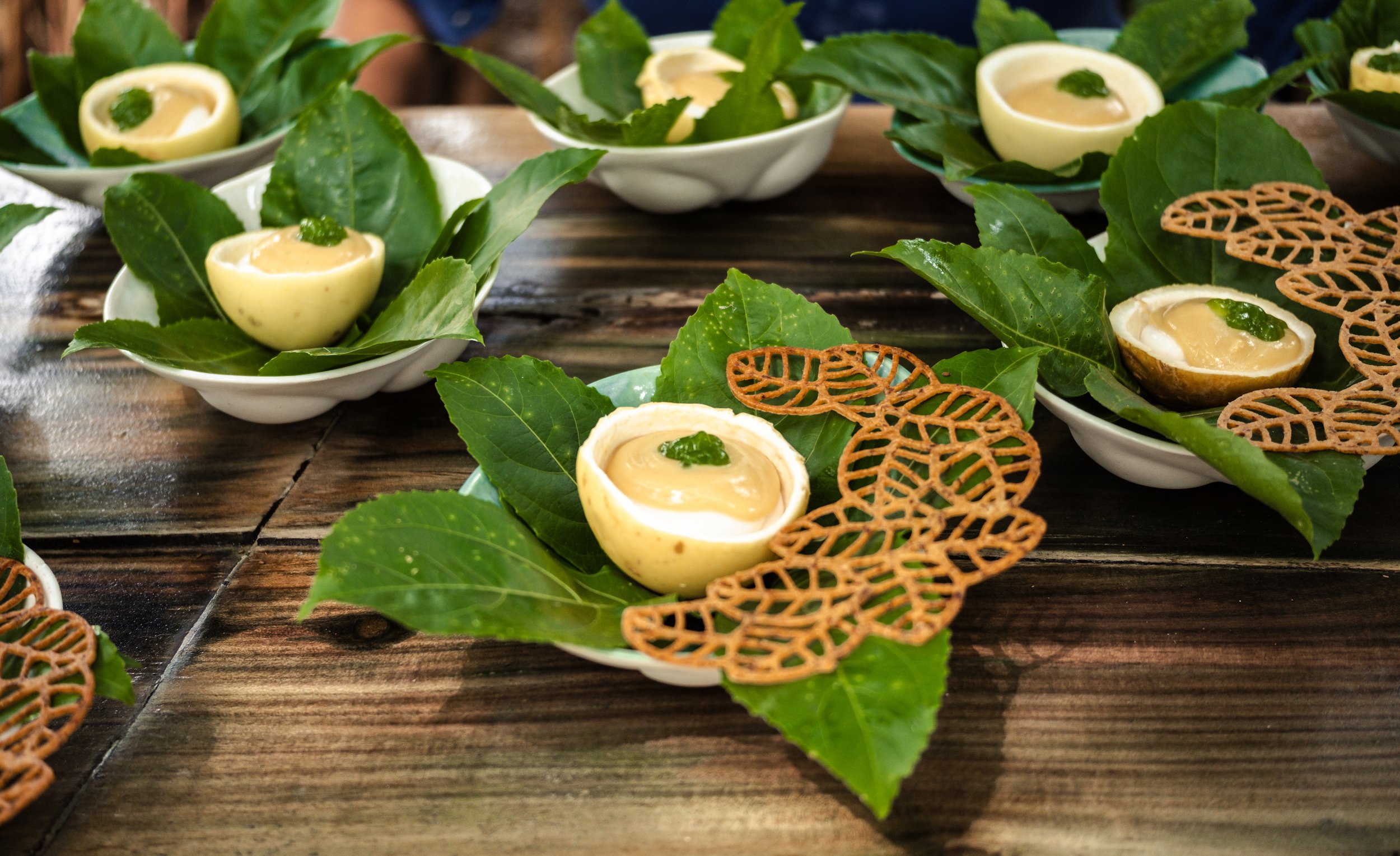 coconut yogurt in a passionfruit shell on a plate of leaves