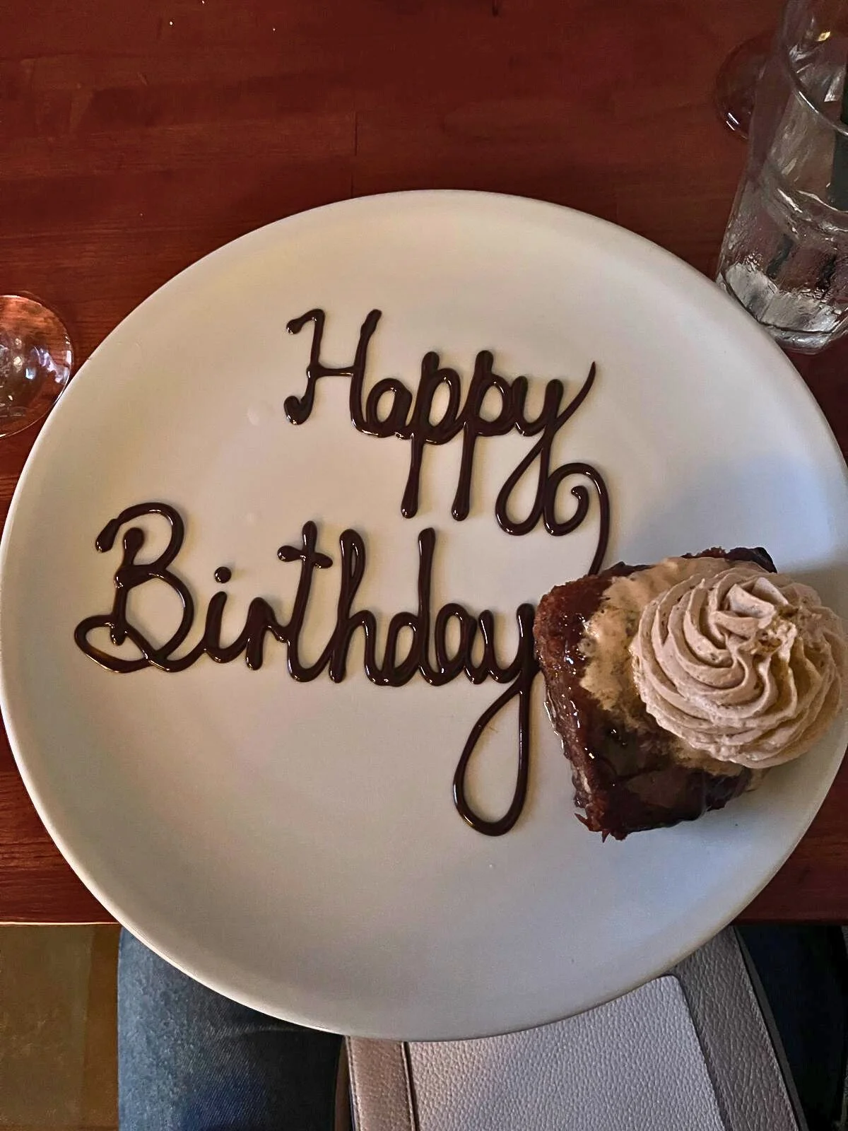 happy birthday written in chocolate on a white plate