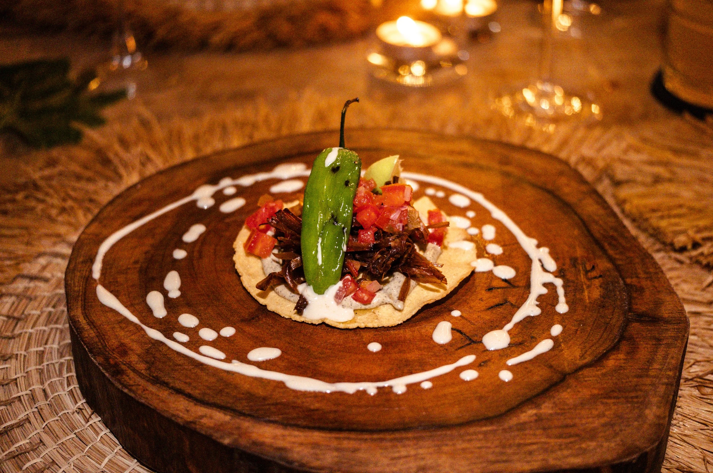 jackfruit taco with a shishito pepper on a wooden plank