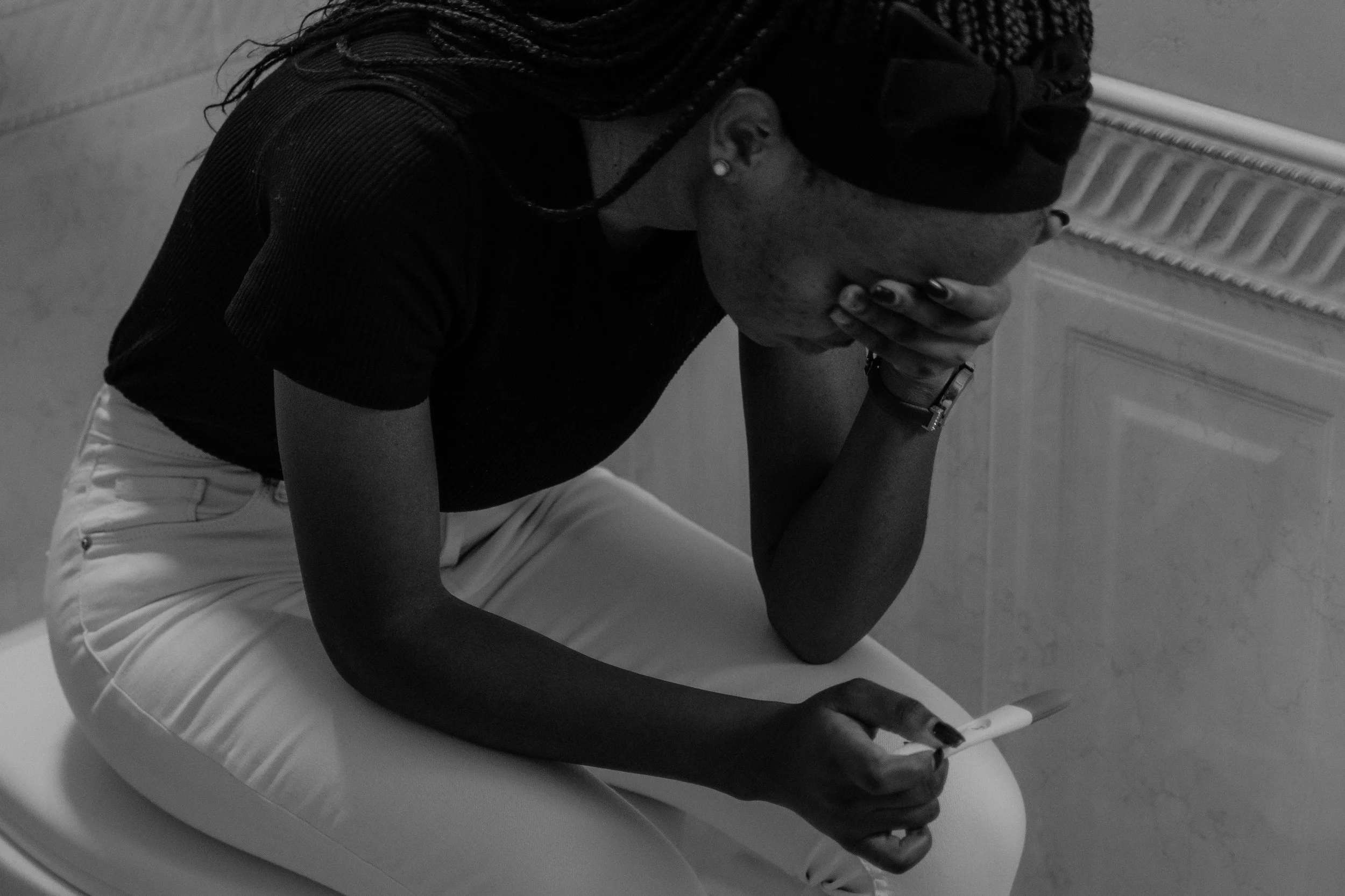 Woman crying after a negative pregnancy test following miscarriage. Perinatal and maternal mental health therapist specializing in relationship and couples therapy. Licensed in CA, FL, VA, TX, & ID.