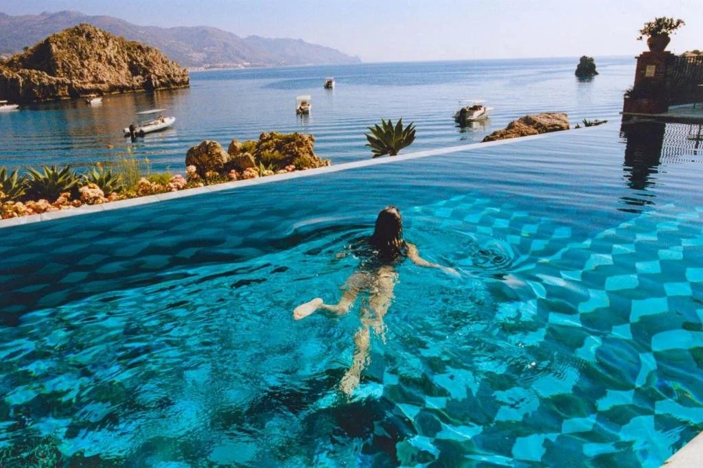 Villa Sant'Andrea Taormina infinity pool with rocks and boats in Mazzarò Bay