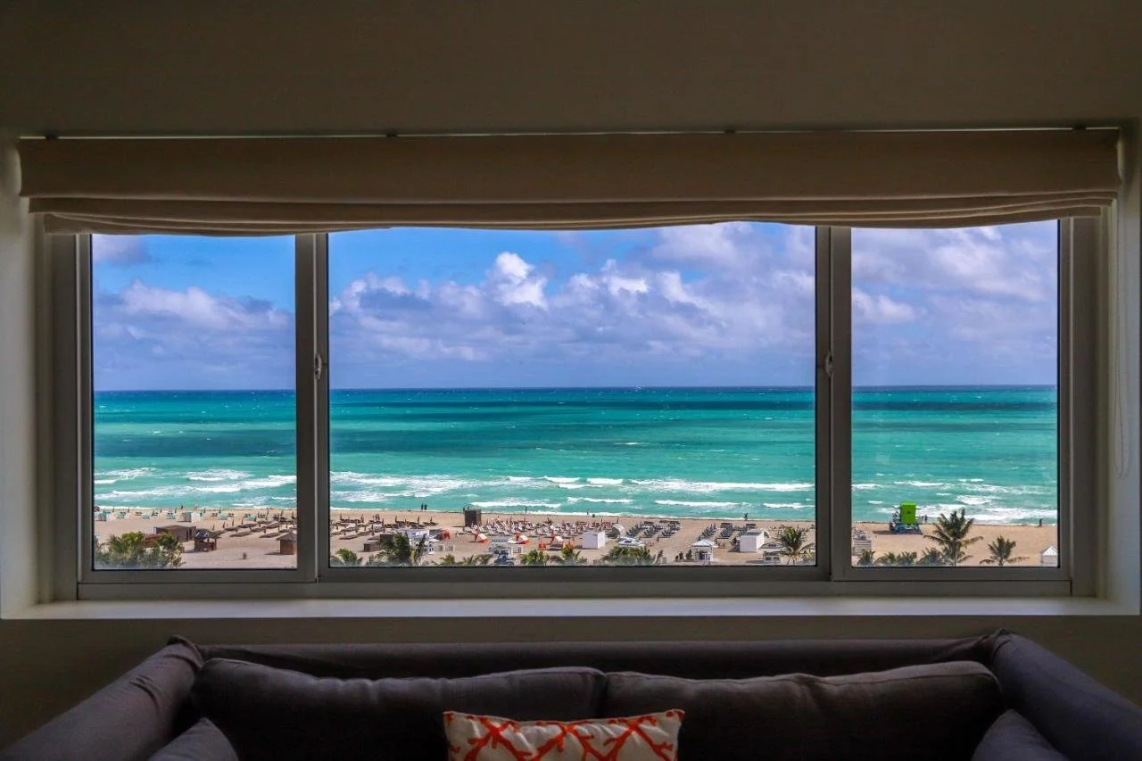 Nautilus Sonesta Miami Beach room triple-panel window view of Miami Beach sand, beach cabanas and turquoise Atlantic Ocean