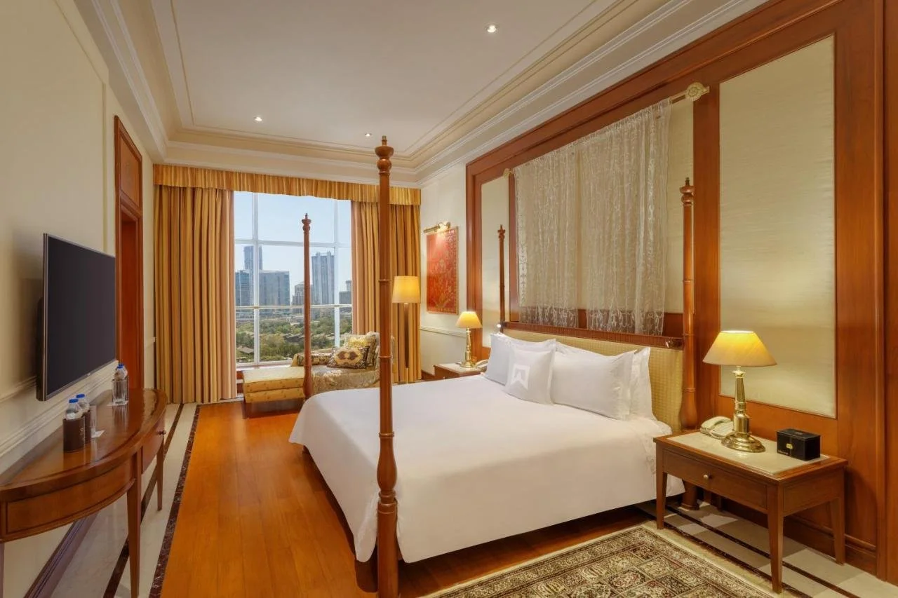 ITC Grand Central Mumbai Tower Room with four-poster mahogany bed and city skyline view through the window