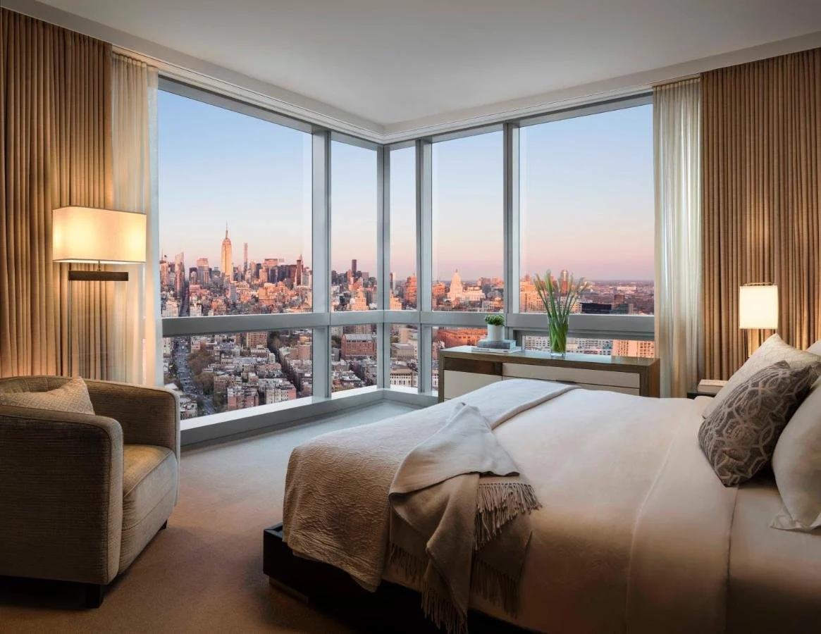 The Dominick Hotel New York SoHo corner suite with floor-to-ceiling wraparound windows and Midtown skyline at golden hour