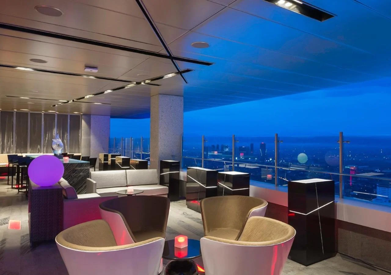 Marco Polo Ortigas Manila Vu's Sky Bar at night with pod seating and open panoramic views of the Metro Manila cityscape extending to the horizon