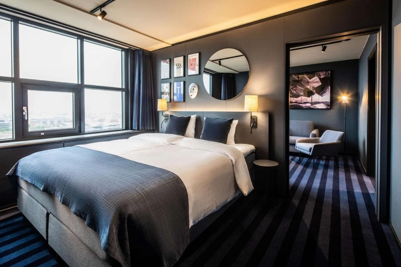 Scandic Falkoner Copenhagen hotel room with city view window and theater-themed dark interior decor