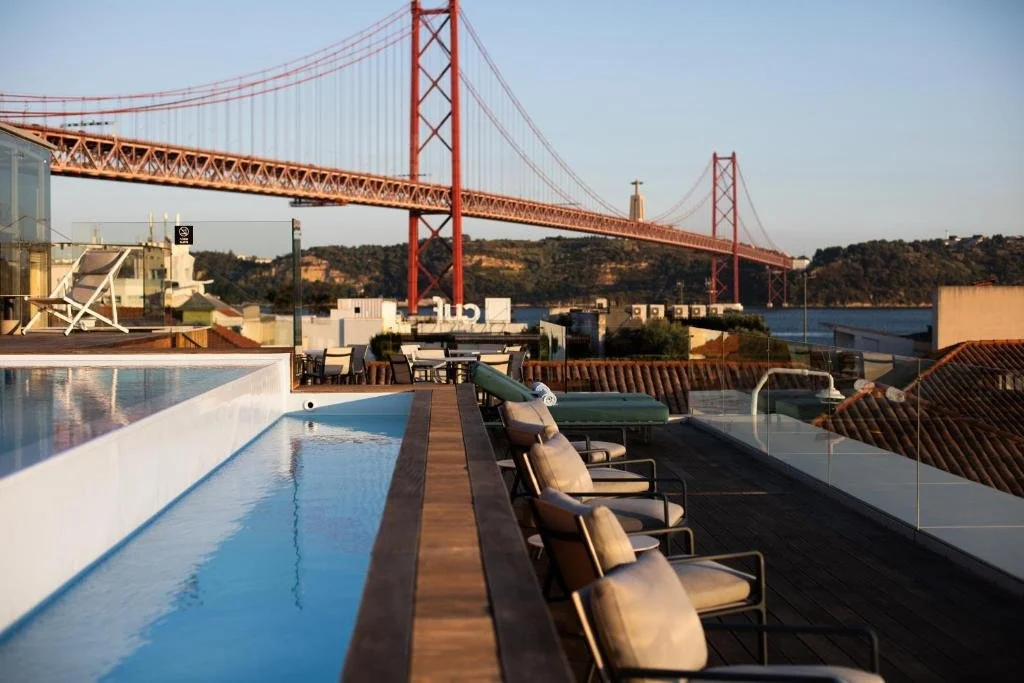 MACAM Hotel Lisbon rooftop pool terrace with Ponte 25 de Abril and Cristo Rei at golden hour