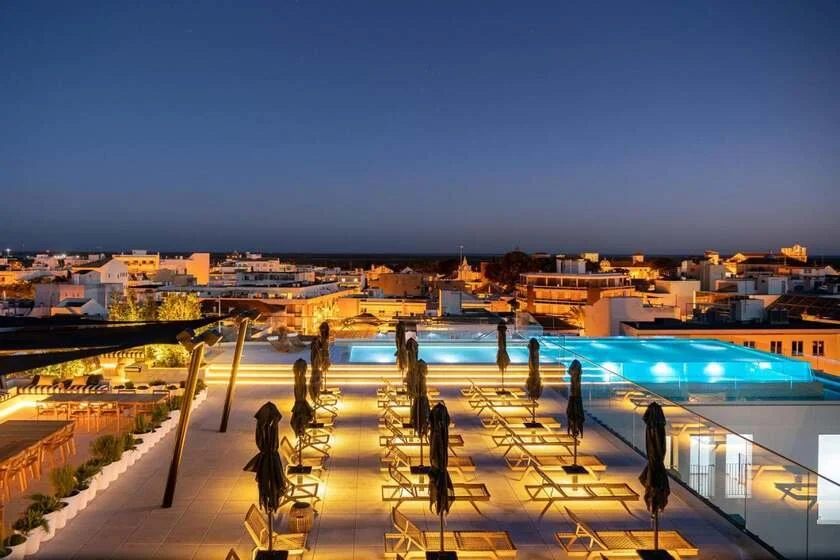 3HB Faro hotel rooftop infinity pool at night with panoramic view over Faro city