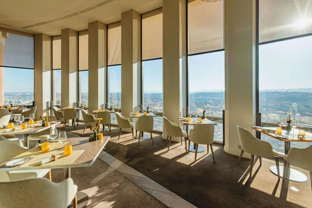 Radisson Blu Hotel Lyon Celest Restaurant dining room on the 32nd floor with panoramic windows and Lyon cityscape and mountains below
